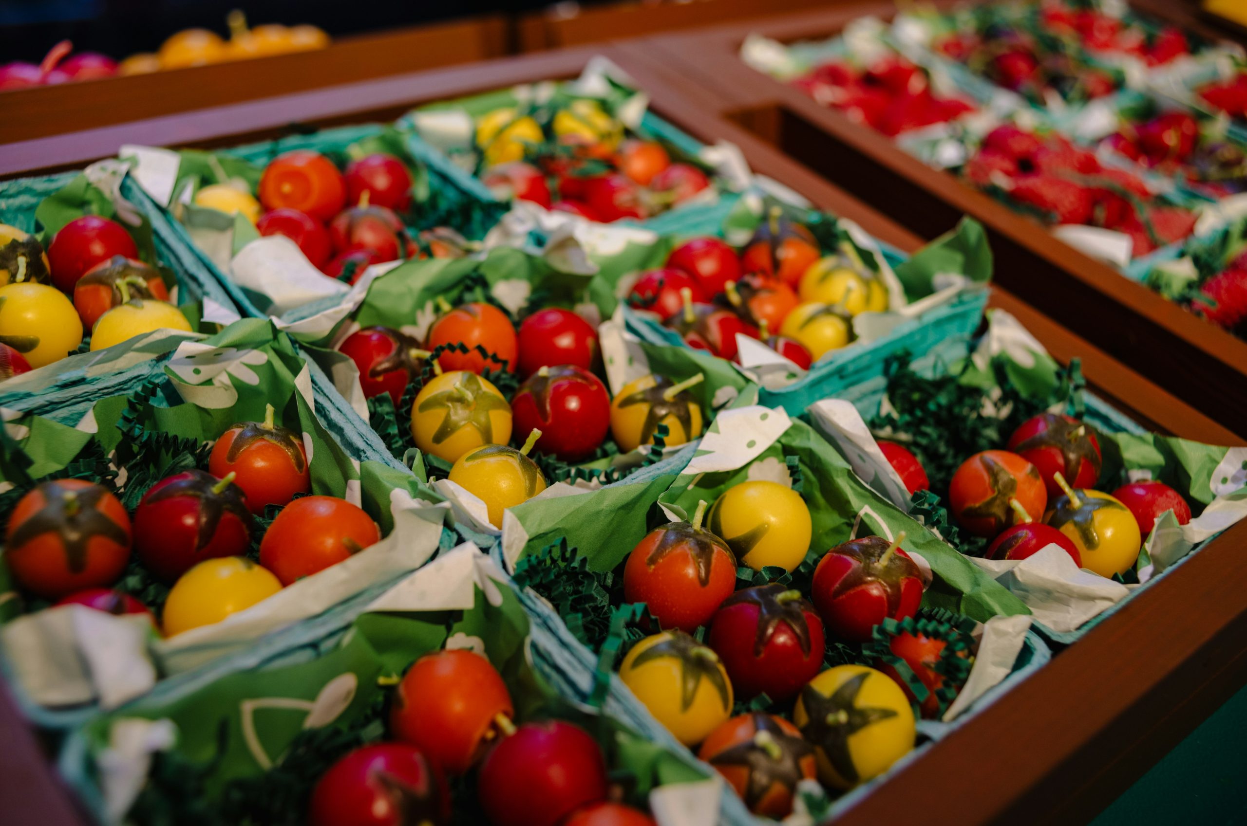 Assortment of colorful cherry tomatoes in green packaging.