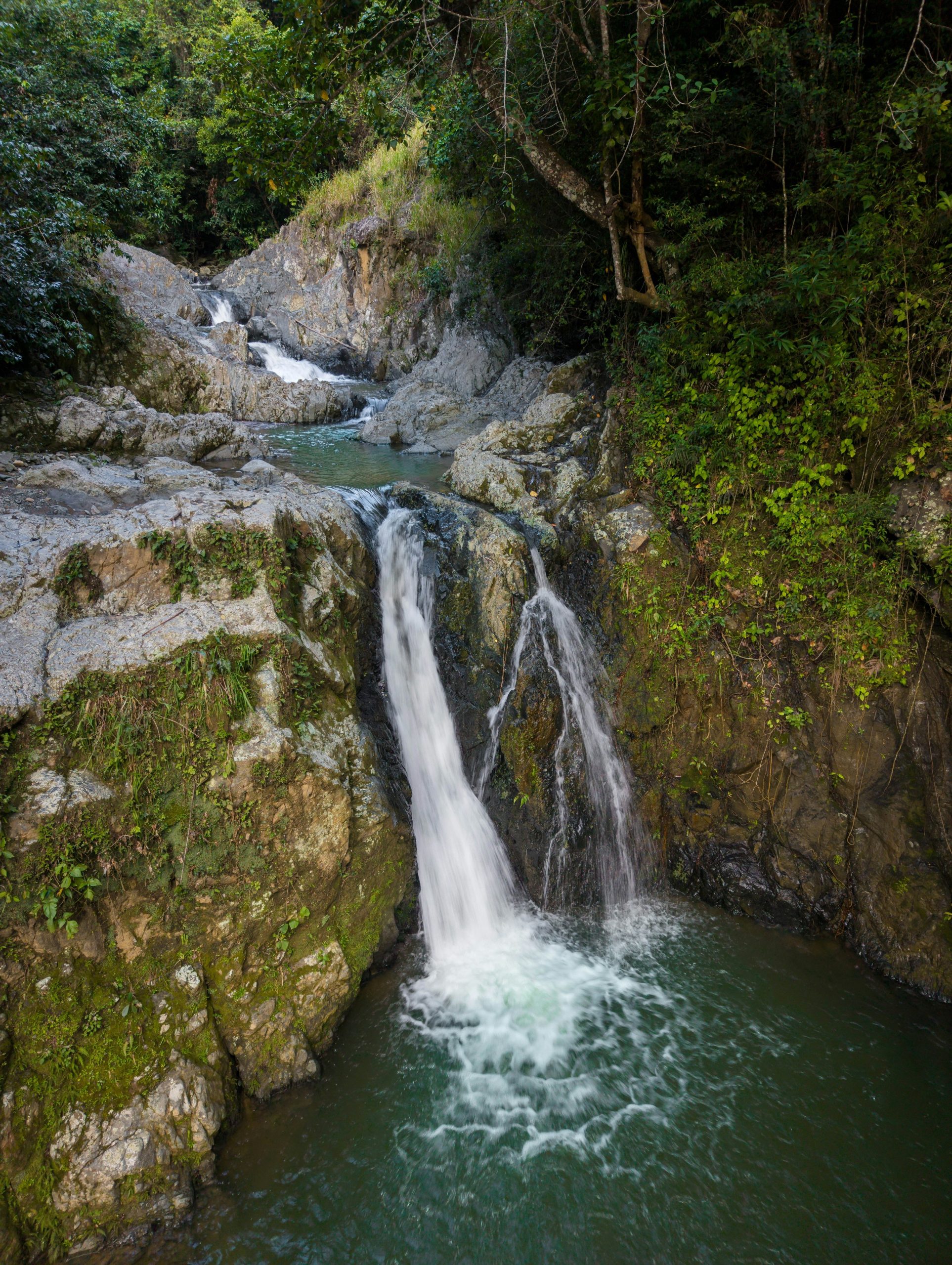 A beautiful waterfall cascades down mossy rocks into a pool.