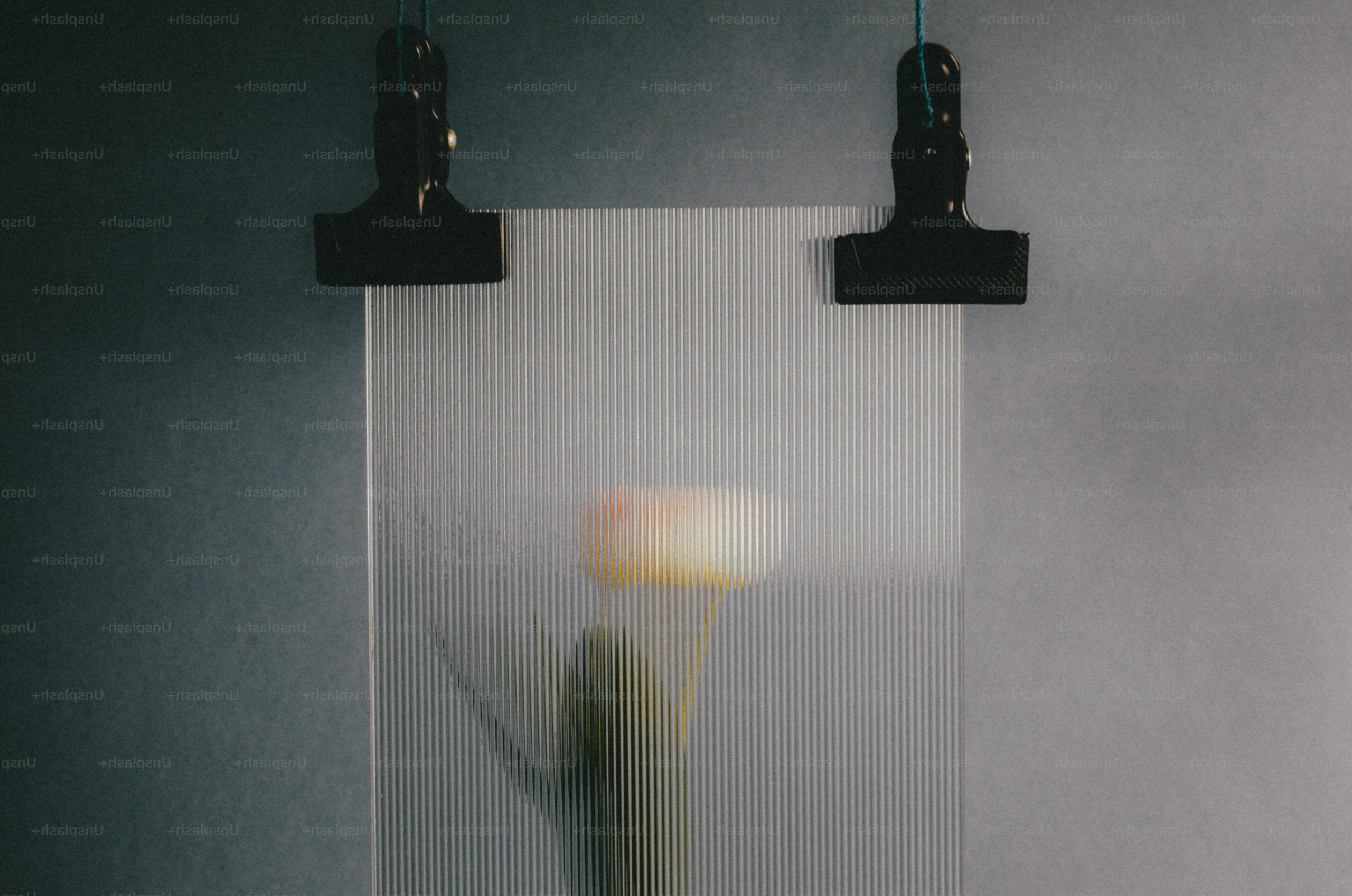 A blurred flower behind a frosted glass pane.