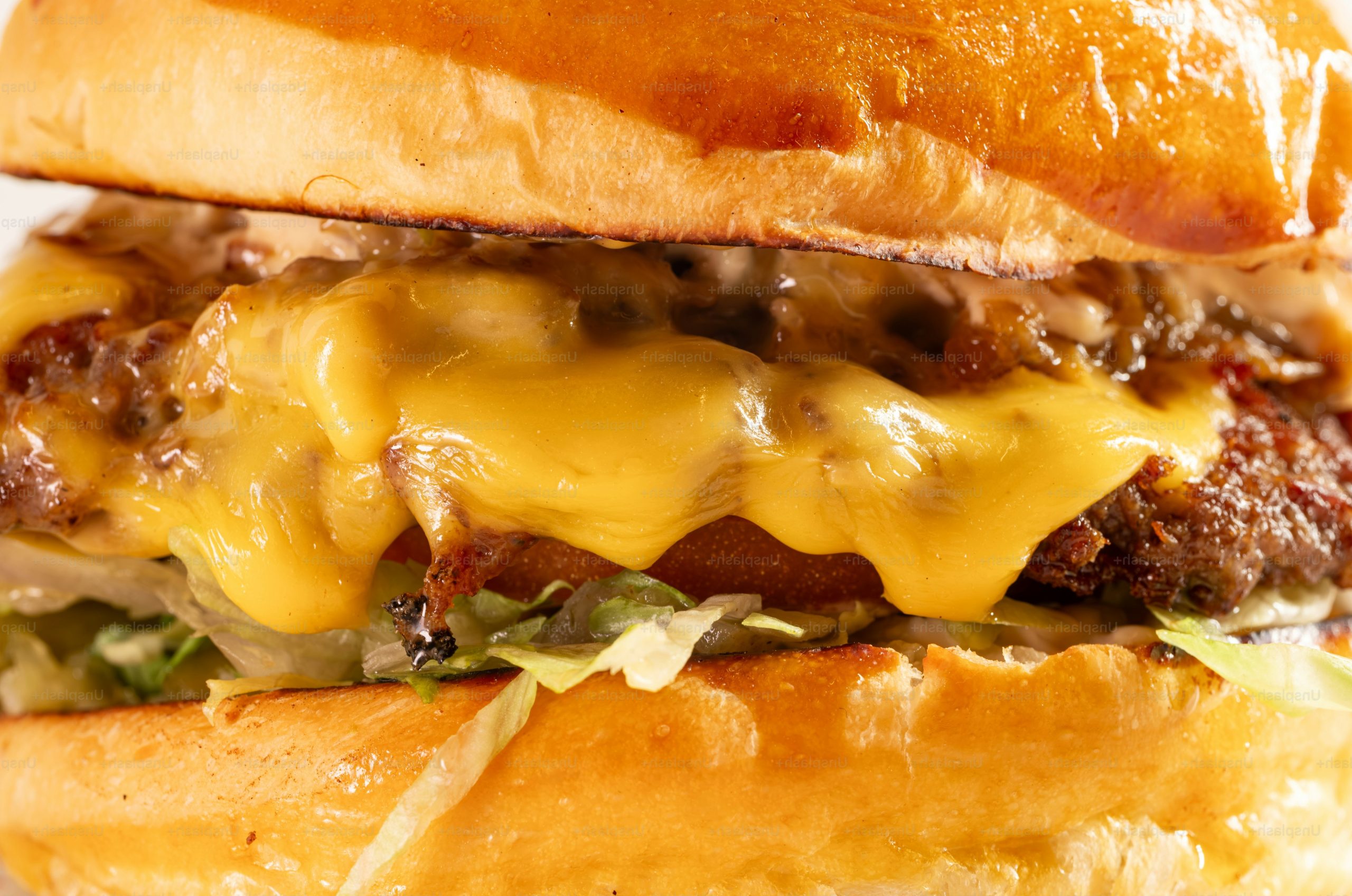 A close-up of a juicy cheeseburger with melted cheese.
