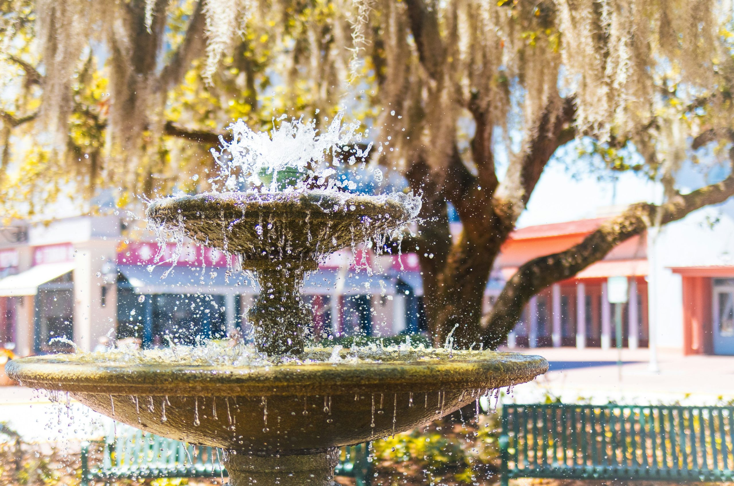 A stone fountain sprays water in a park.