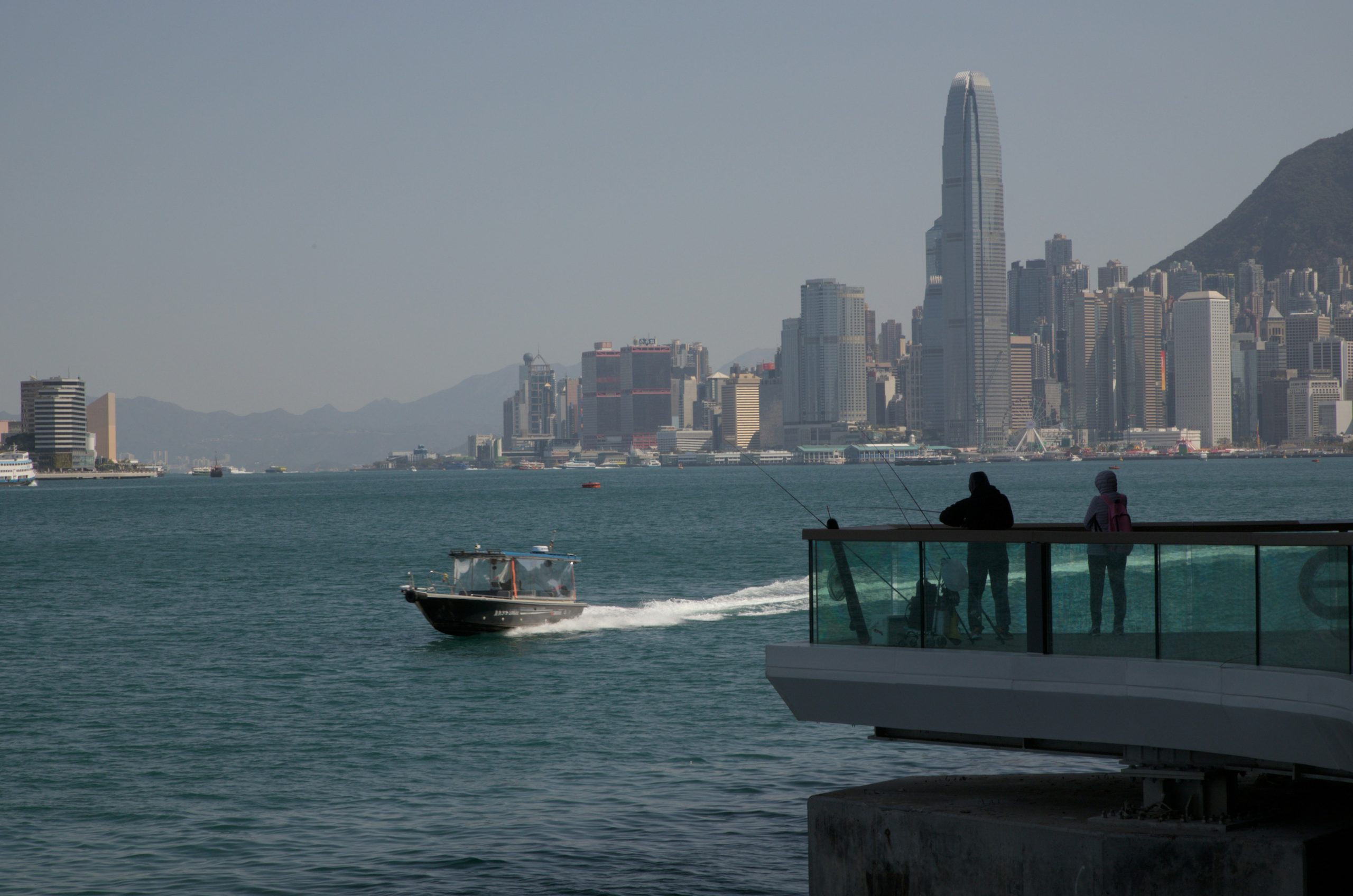 Boats on the water with a city skyline behind.