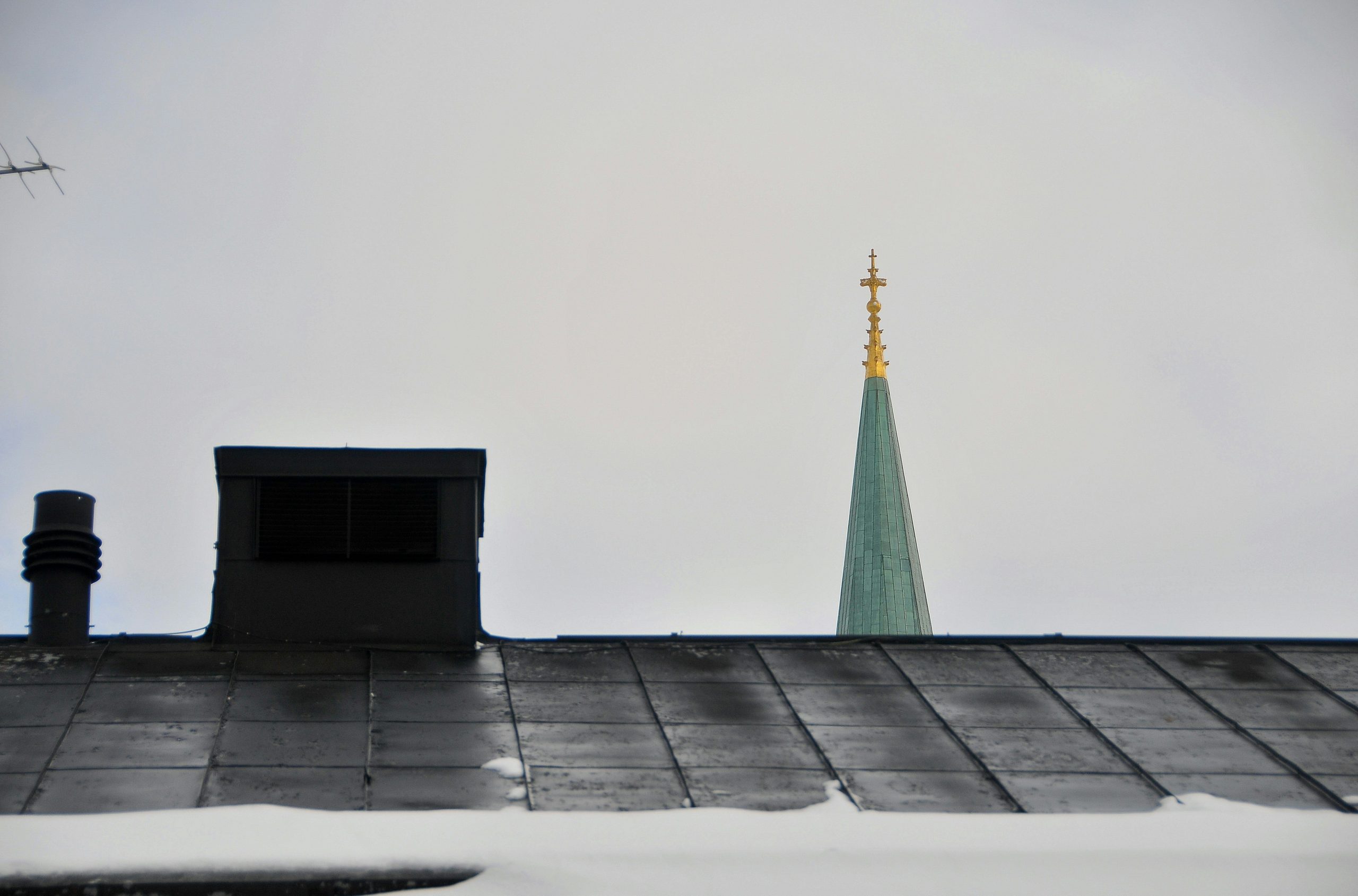 Church steeple and rooftop under a cloudy sky