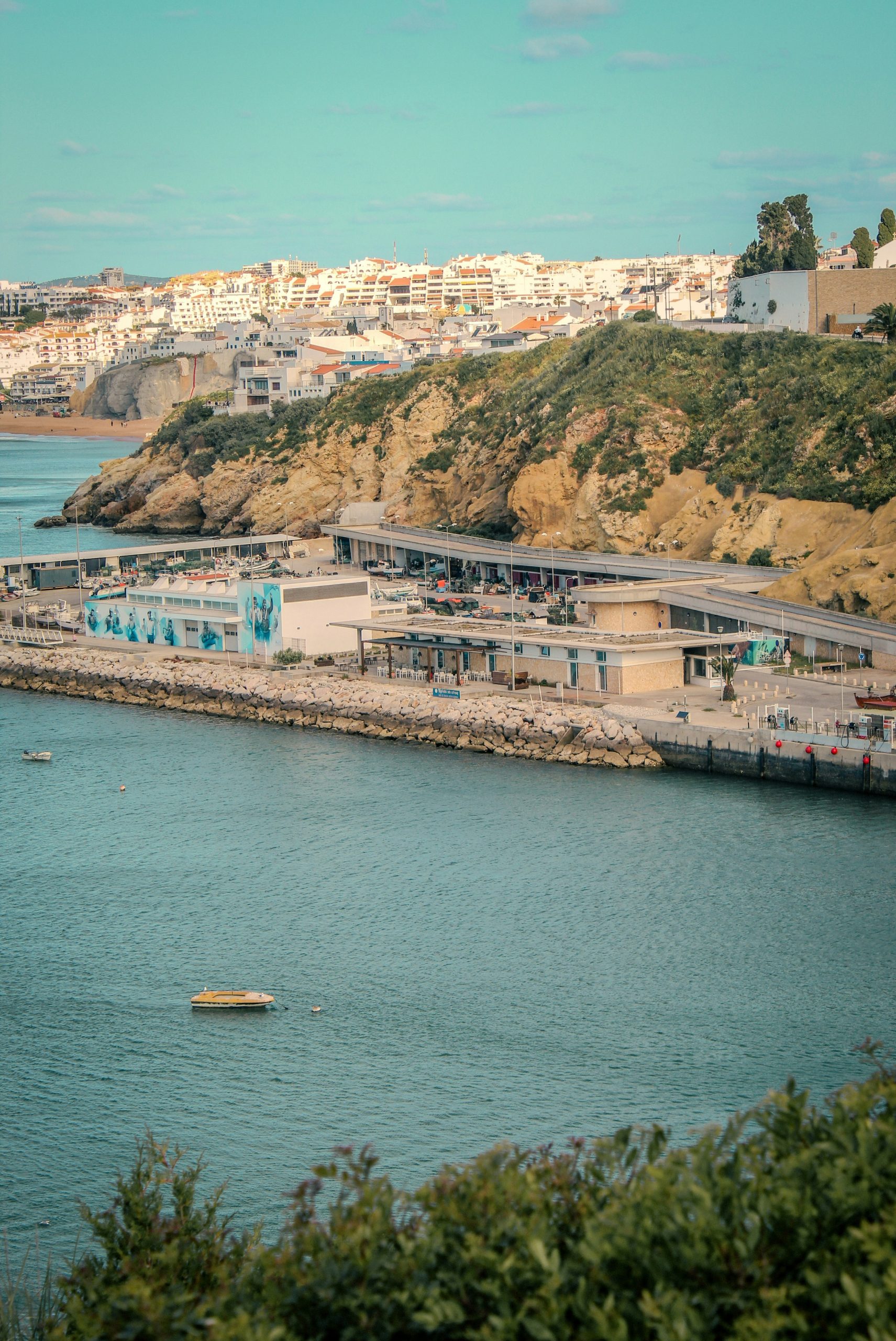 Coastal town with buildings on a hill overlooking the sea.