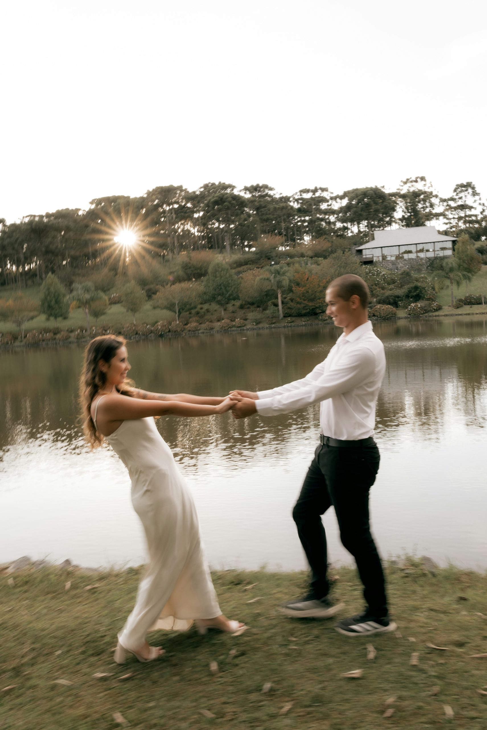 Couple dancing by a lake at sunset