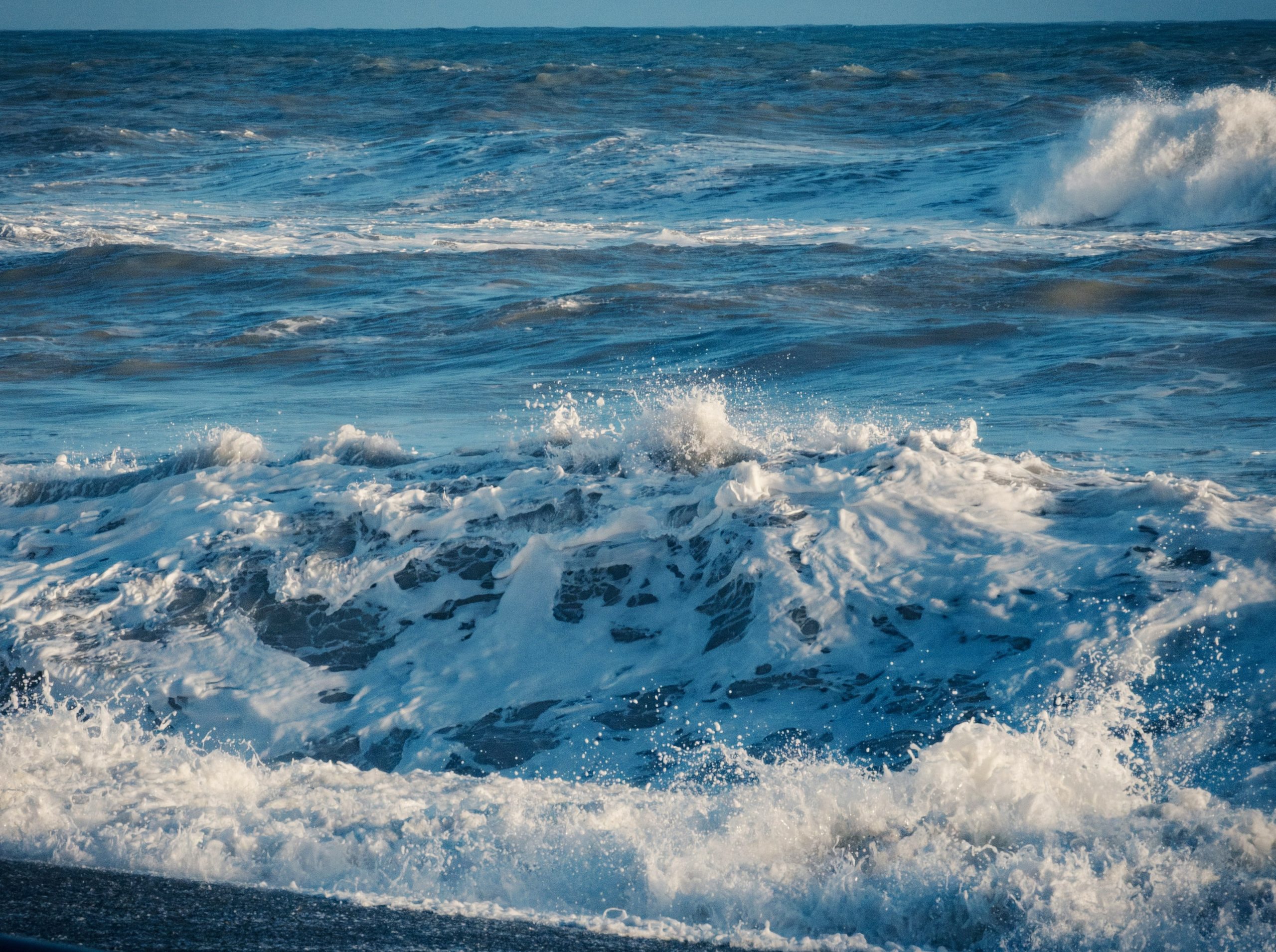 Crashing ocean waves with white foam and blue water