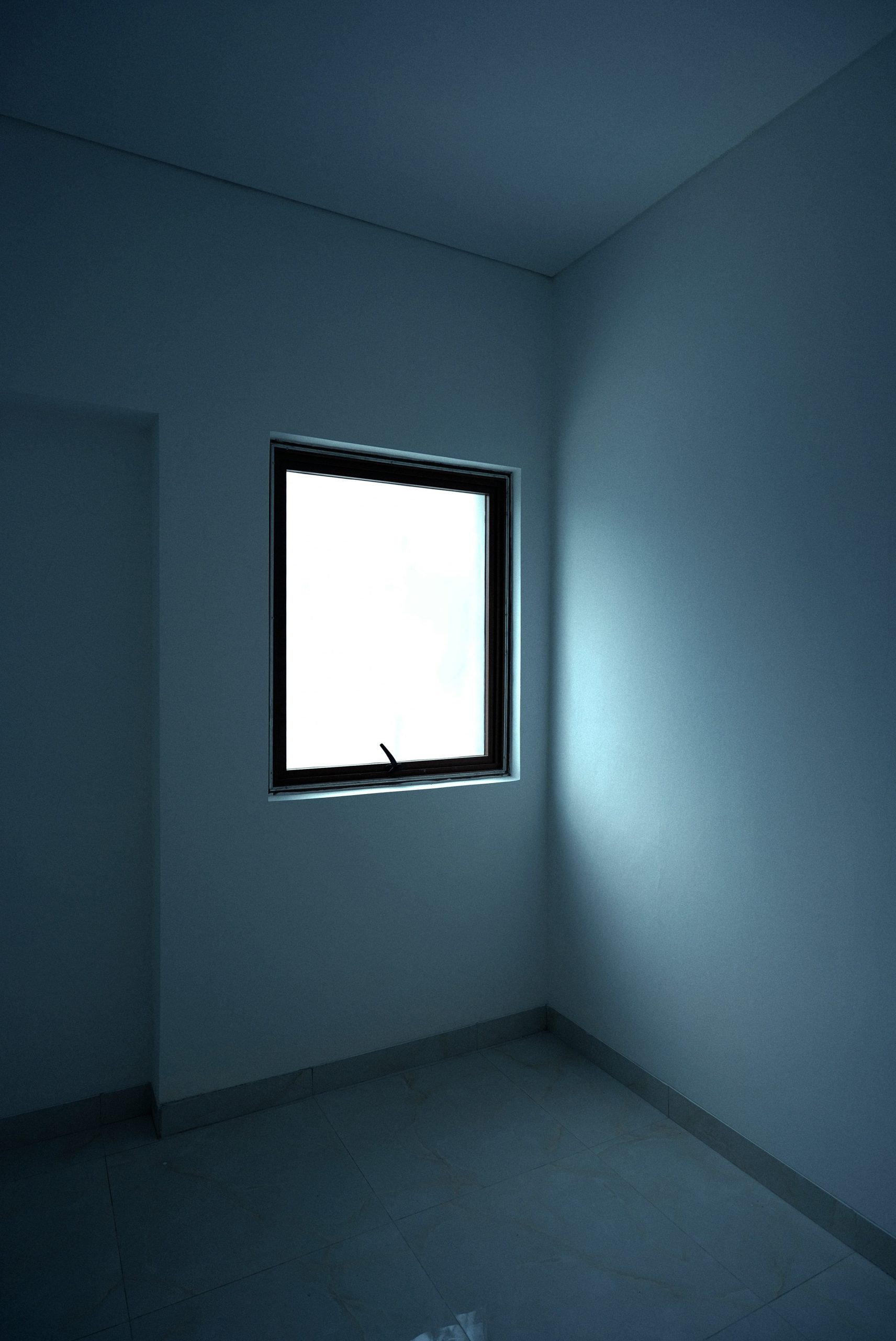 Empty room with a single window and blue walls
