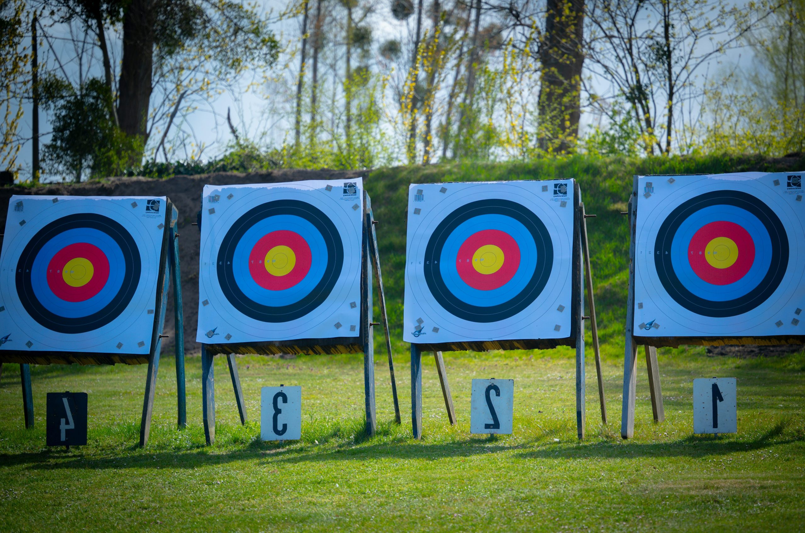 Four archery targets lined up on a grassy field
