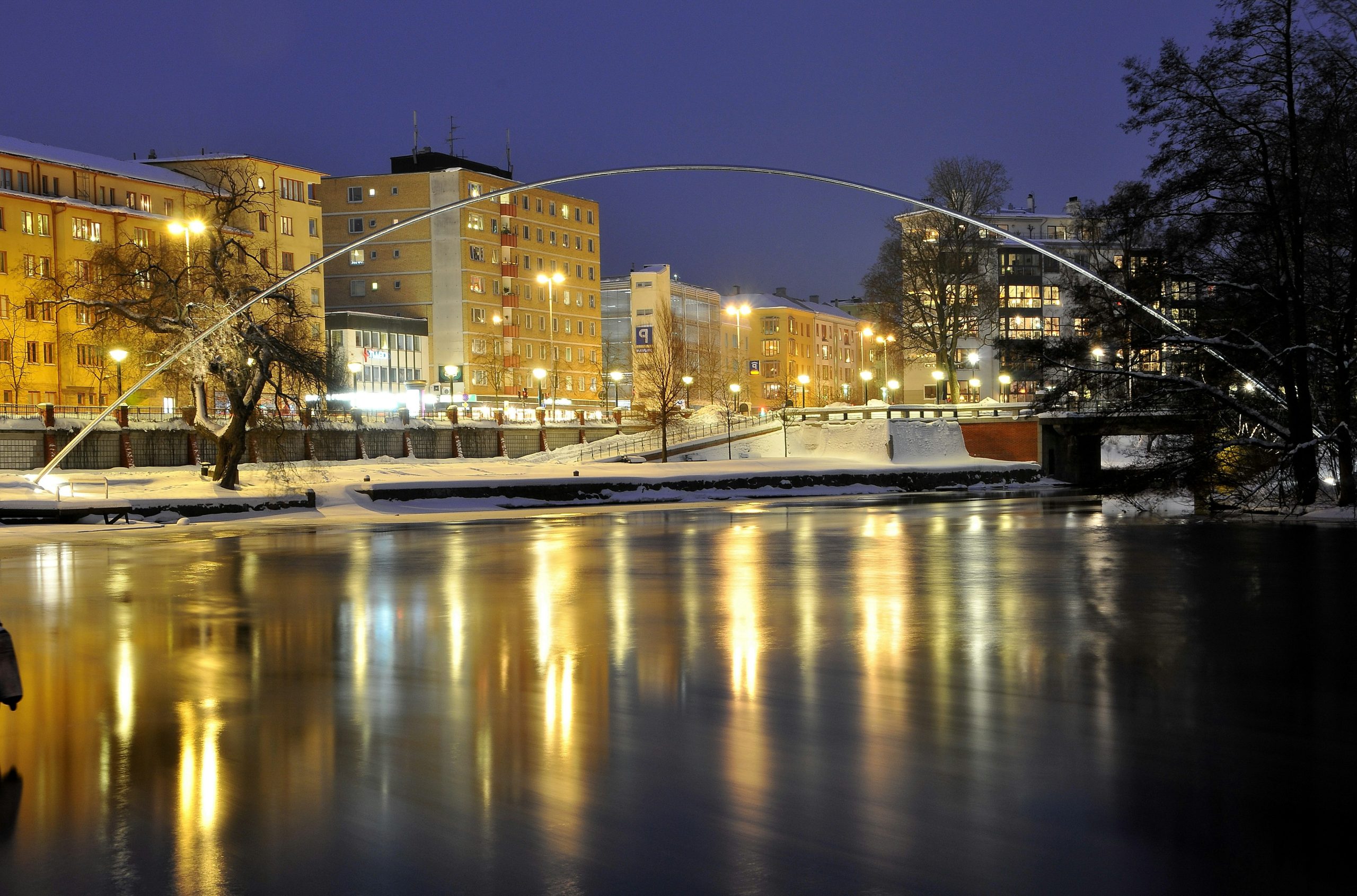 Illuminated bridge over a frozen river at night