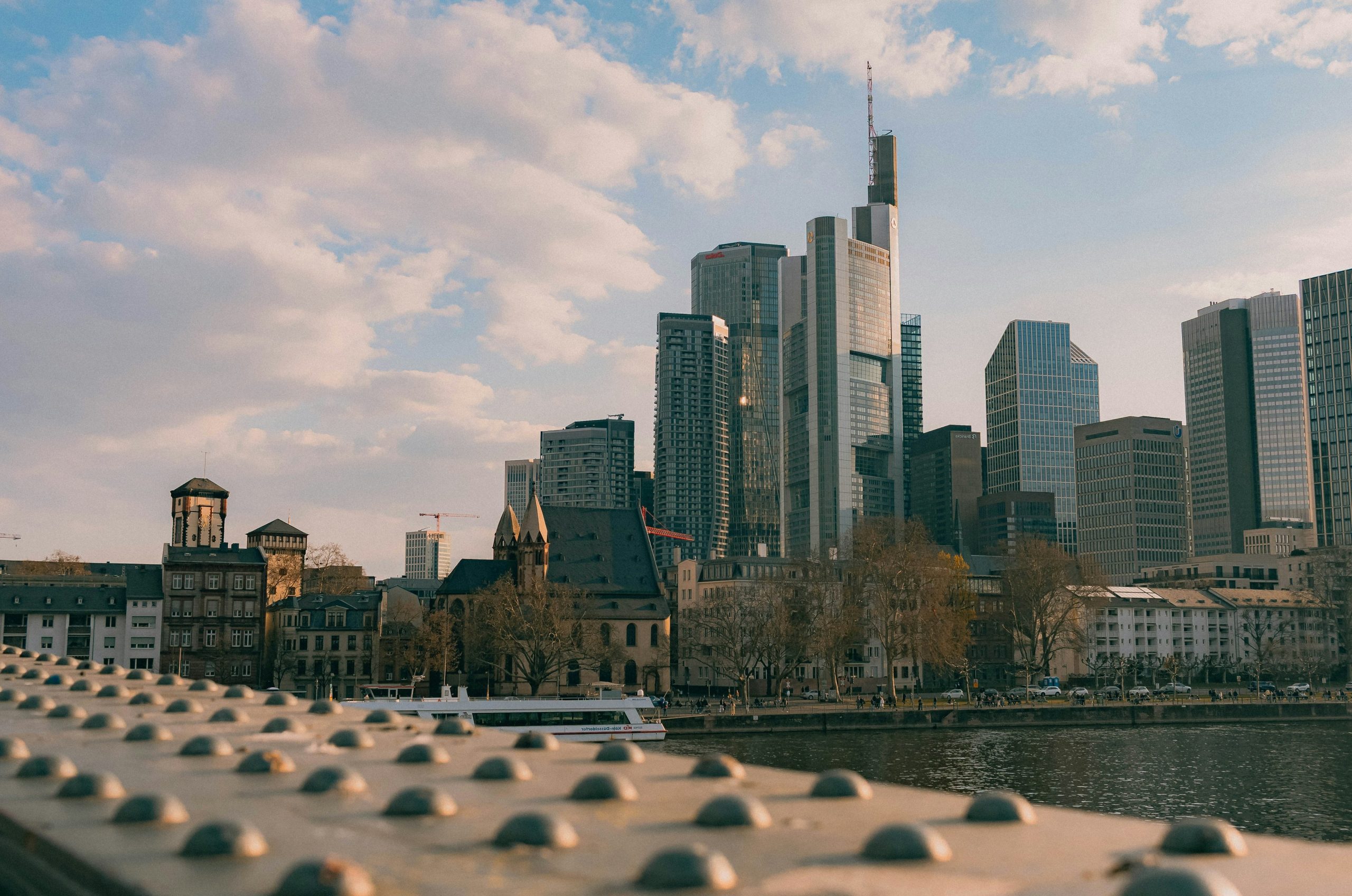 Modern skyscrapers rise above historic buildings in a city.