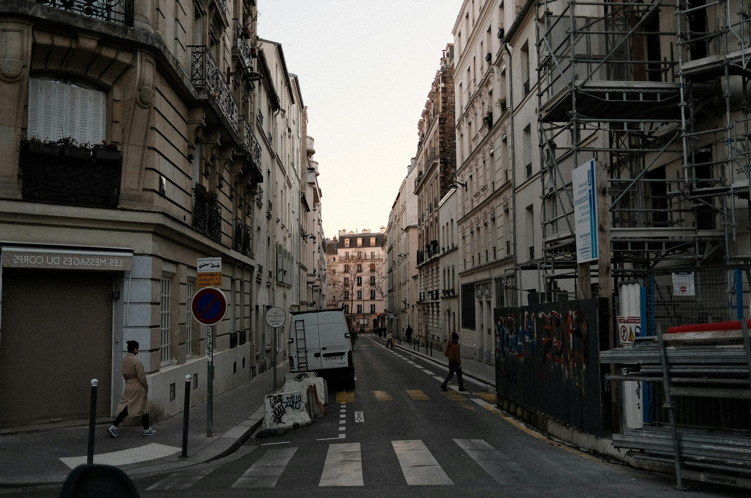 Narrow parisian street with buildings and pedestrians