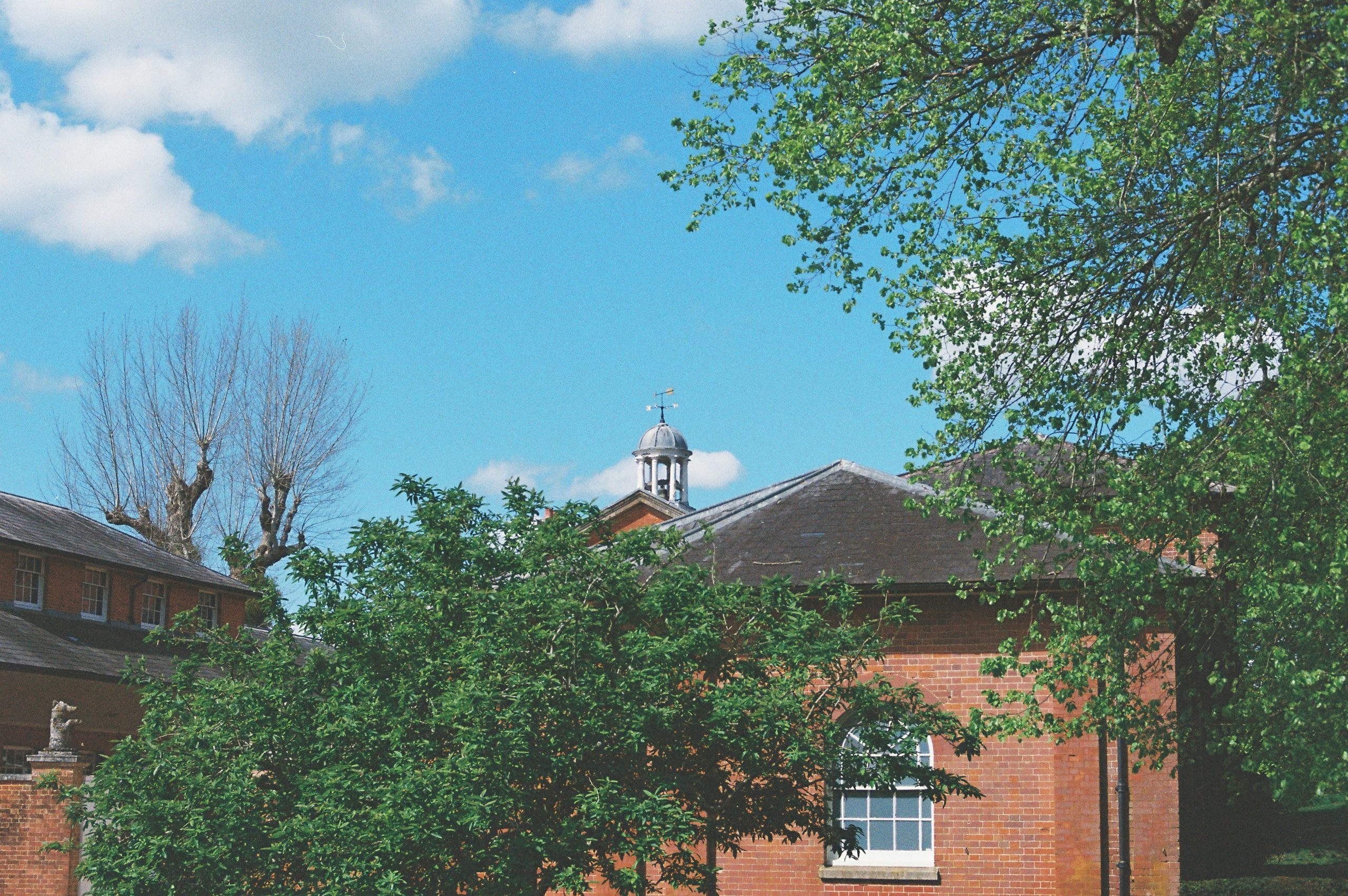 Red brick building with trees and blue sky