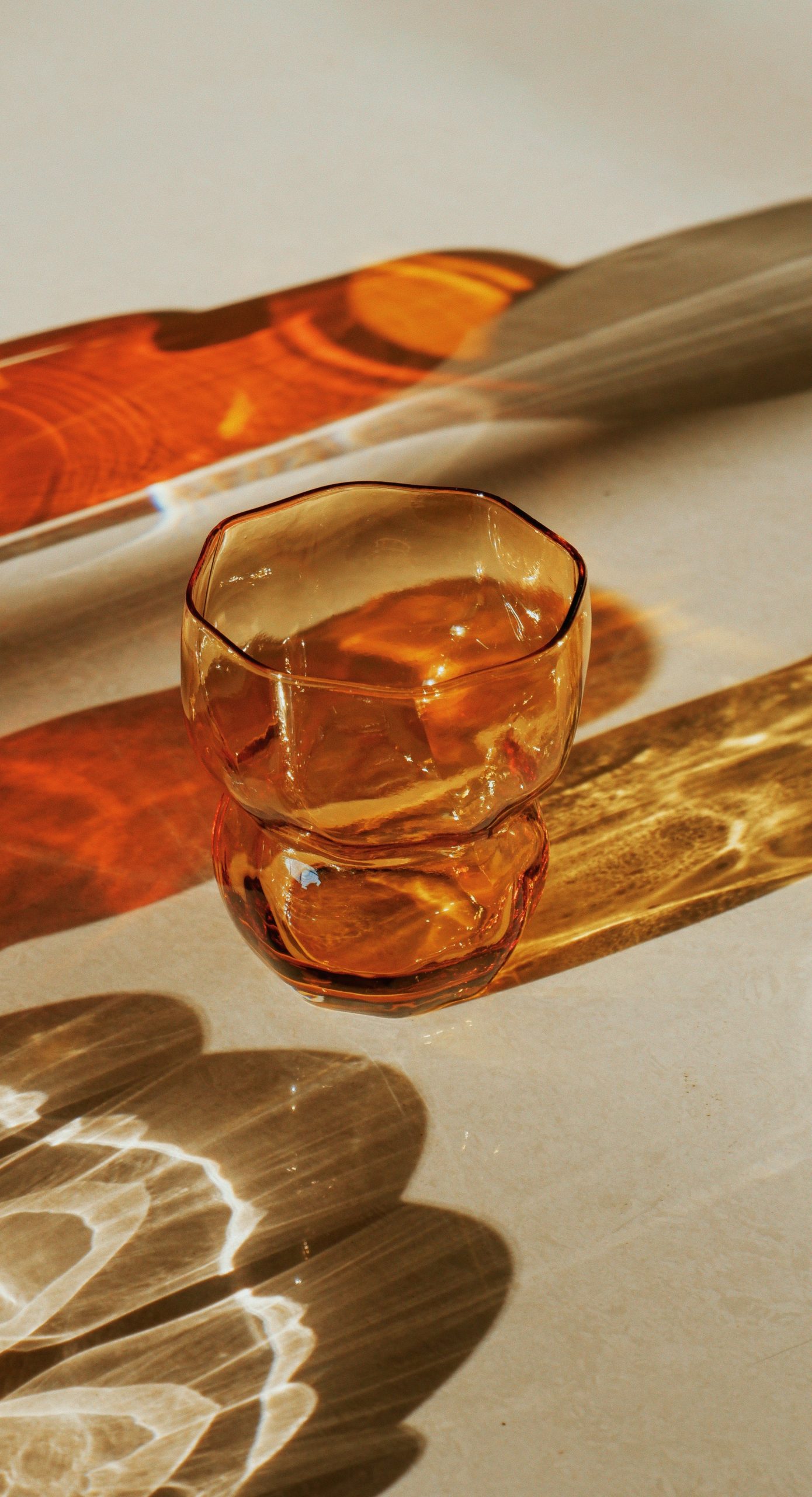 Amber glass cup with dramatic light and shadow patterns