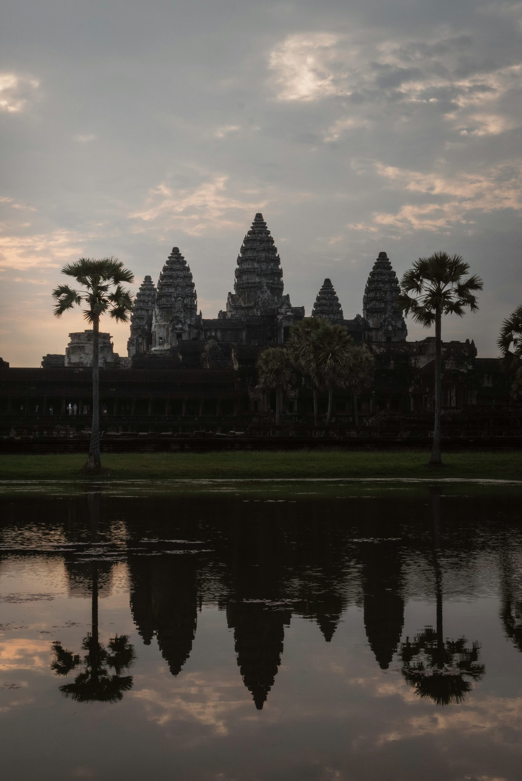 Angkor wat temple reflected in water at sunrise.