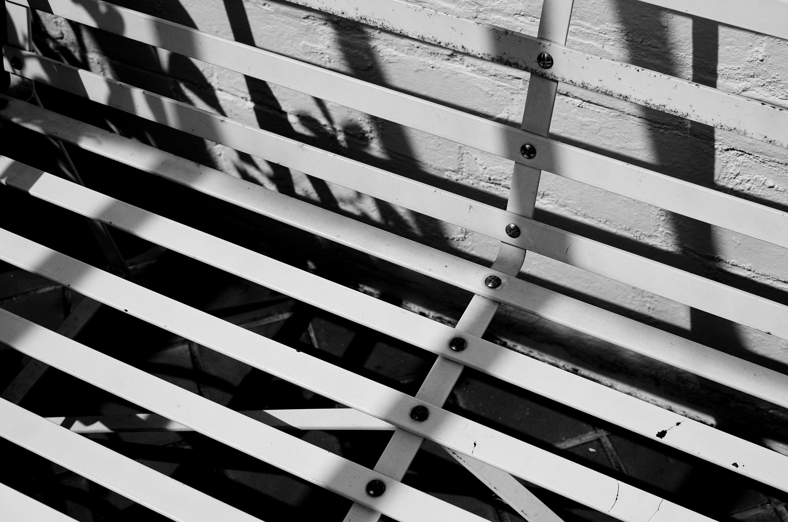 Black and white slatted structure with strong diagonal shadows.