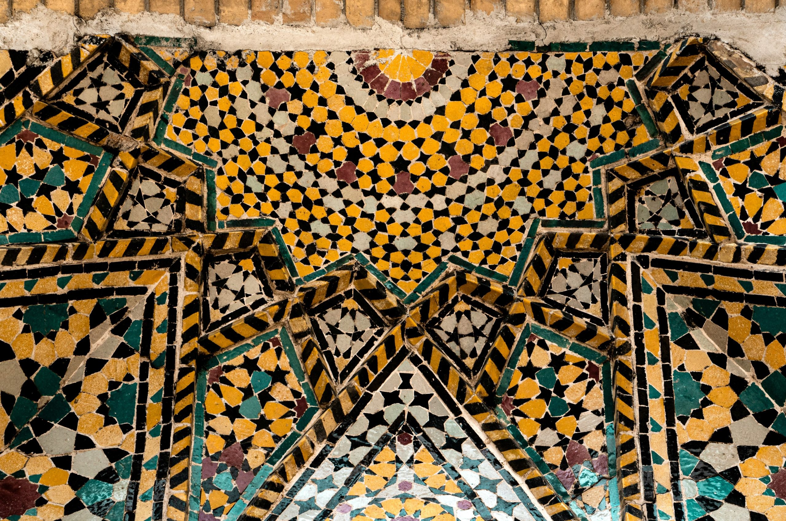 Colorful geometric mosaic tiles adorn a wall.