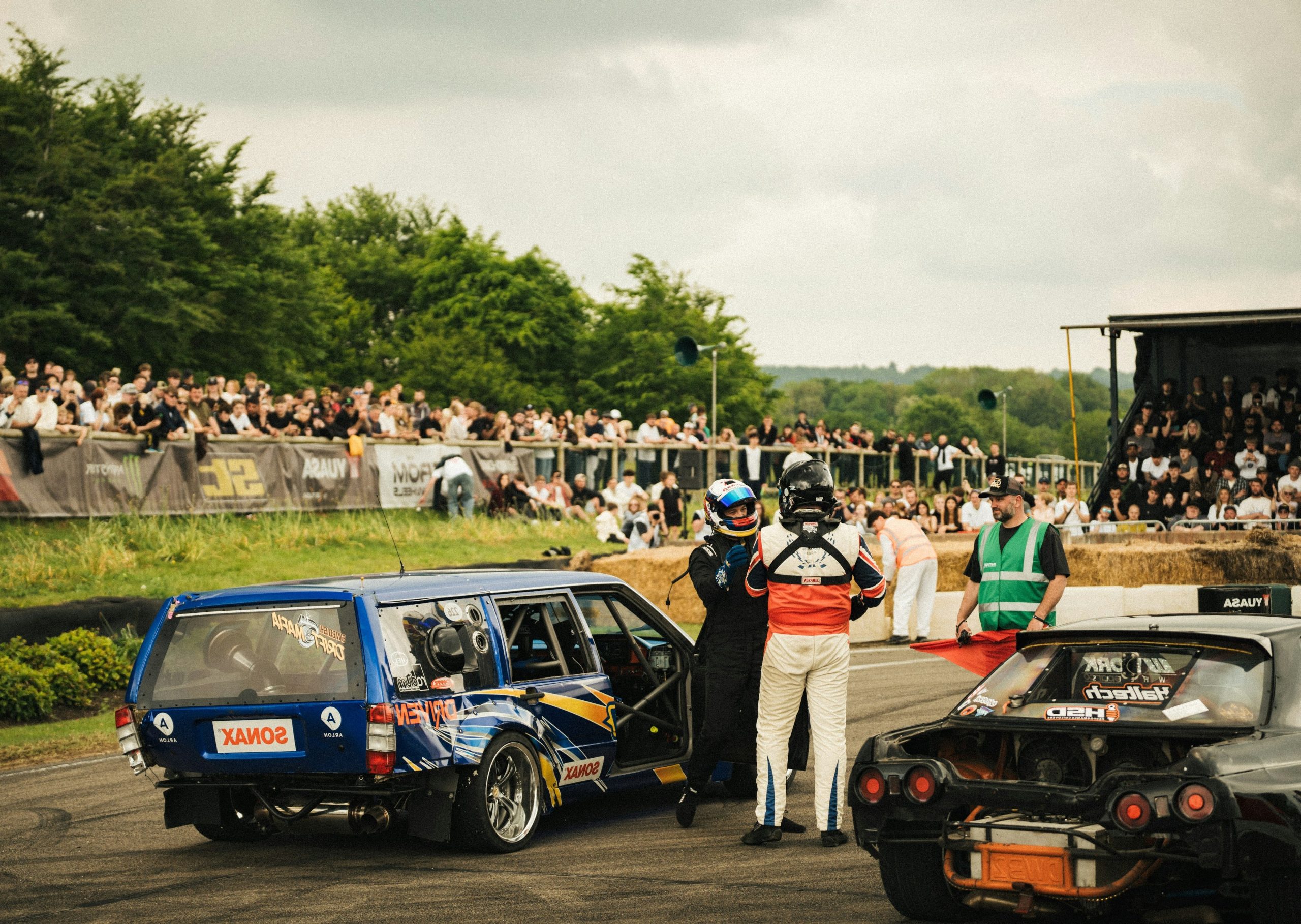 Drivers and crew near modified cars at event