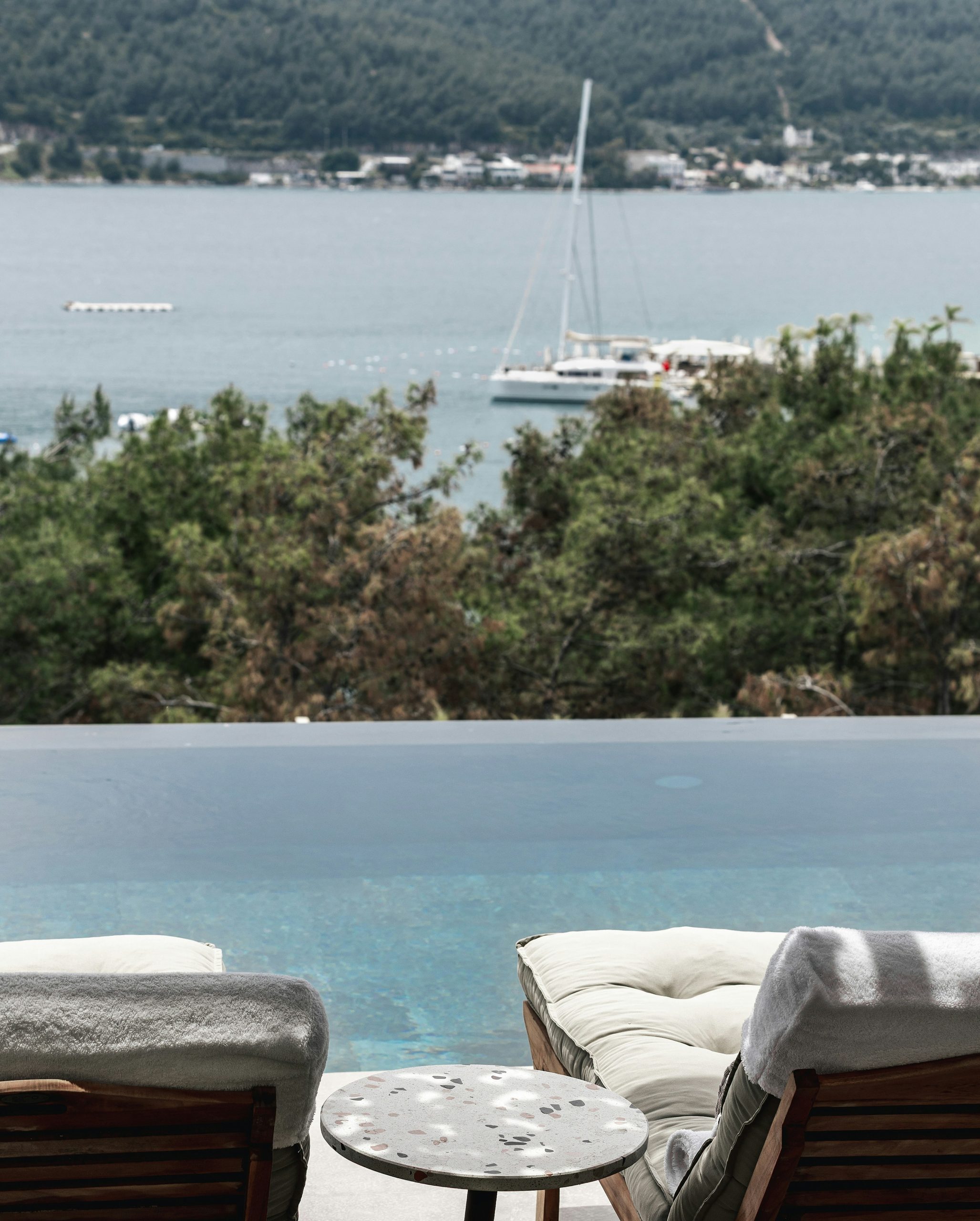 Lounge chairs by an infinity pool overlooking the ocean.