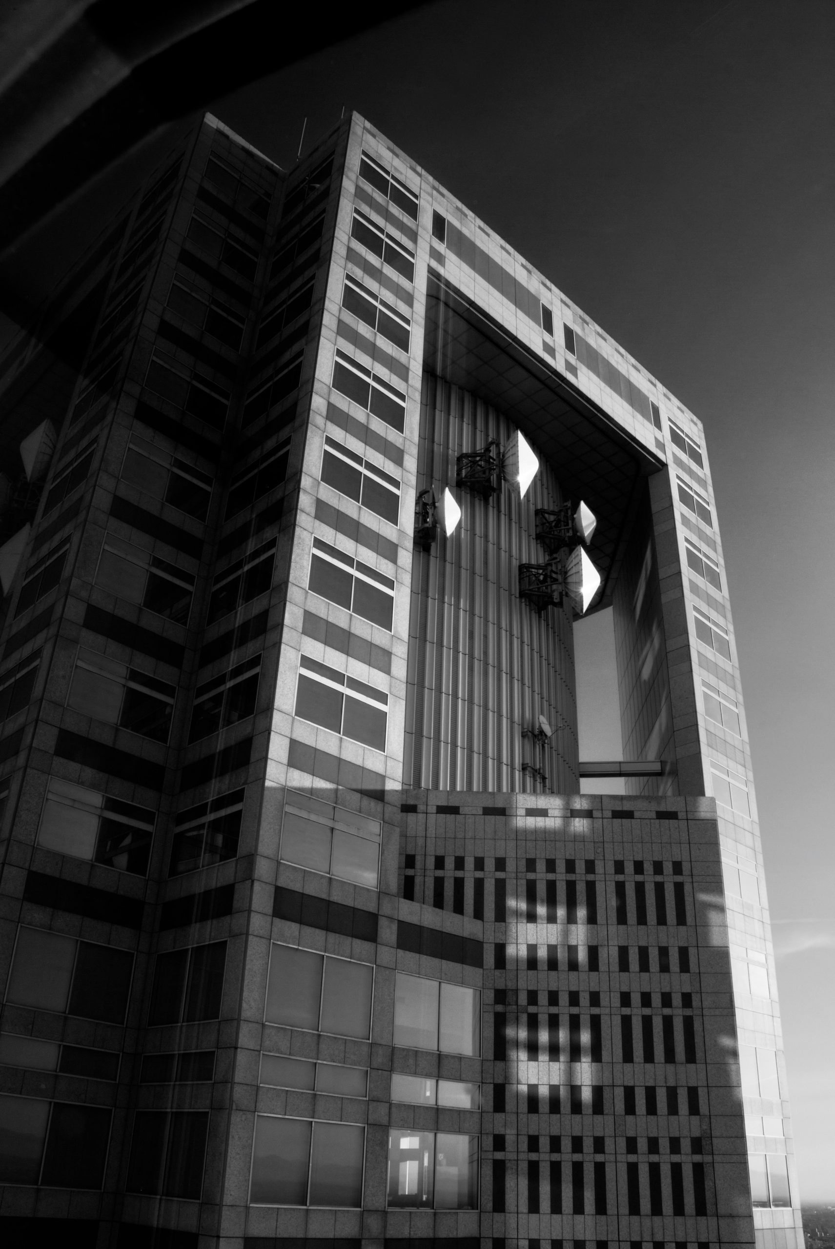 Modern black and white skyscraper with a large architectural opening.