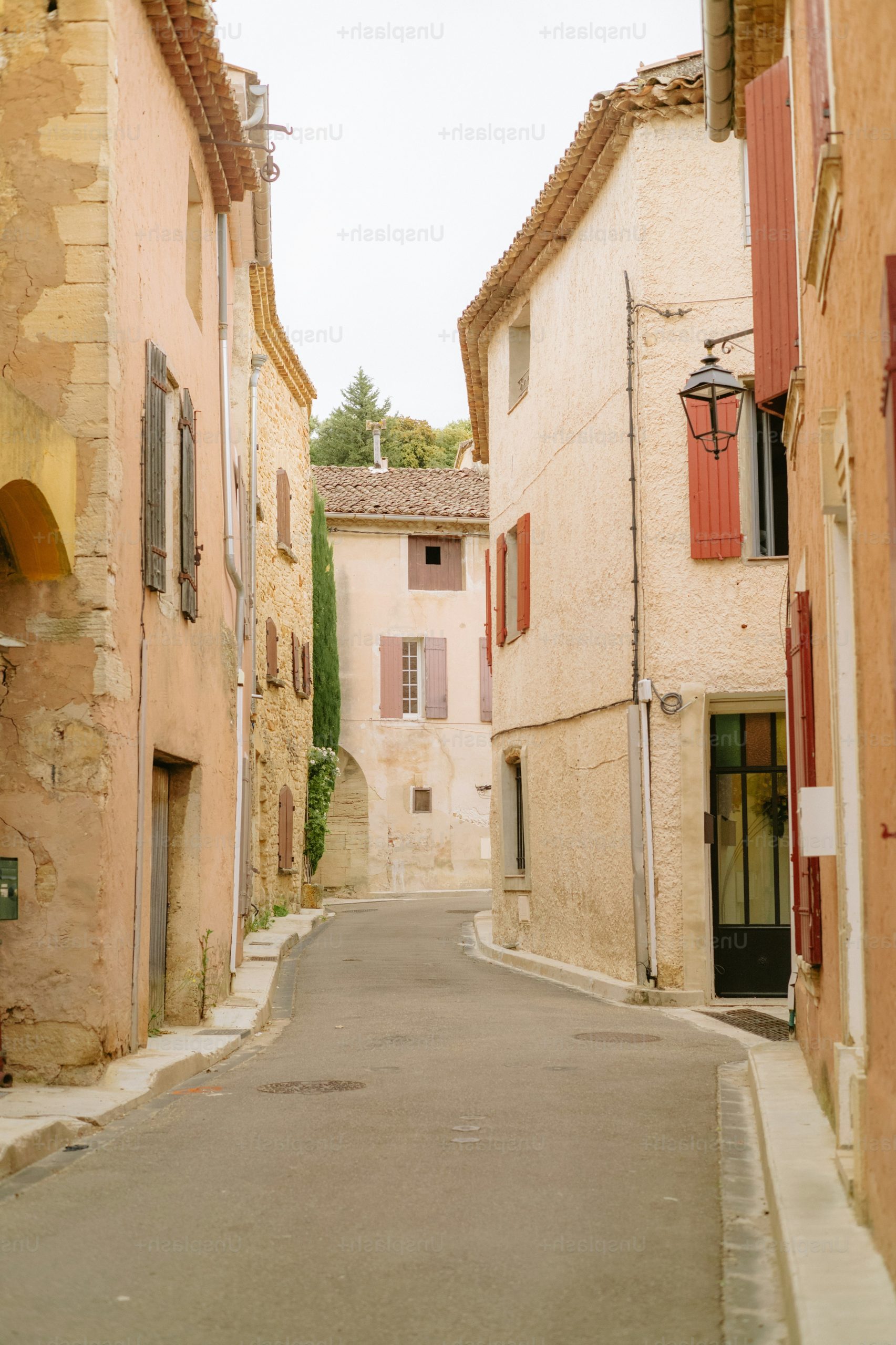 Narrow street with old buildings and red shutters