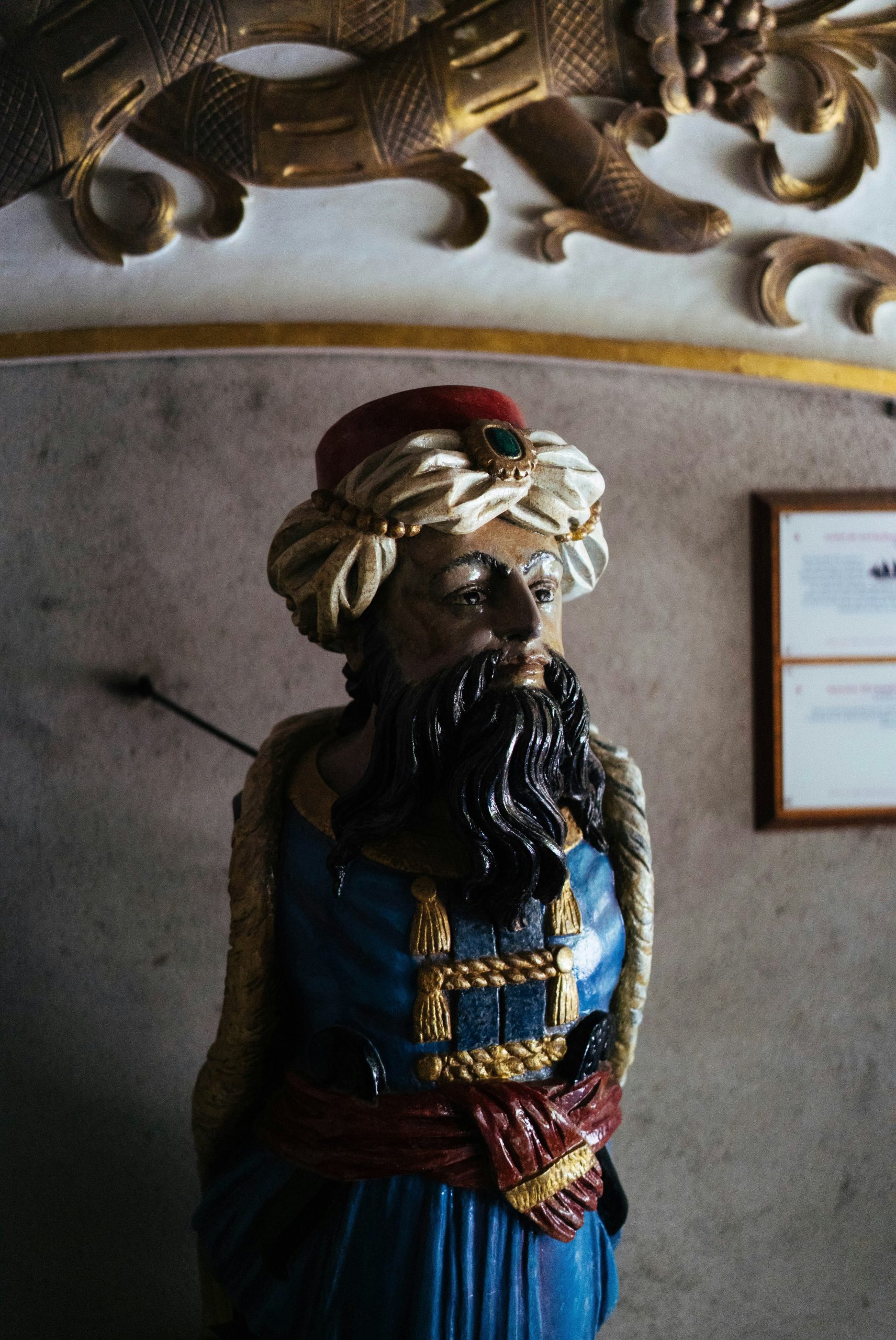 Ornate wooden figurehead of a man in a turban.