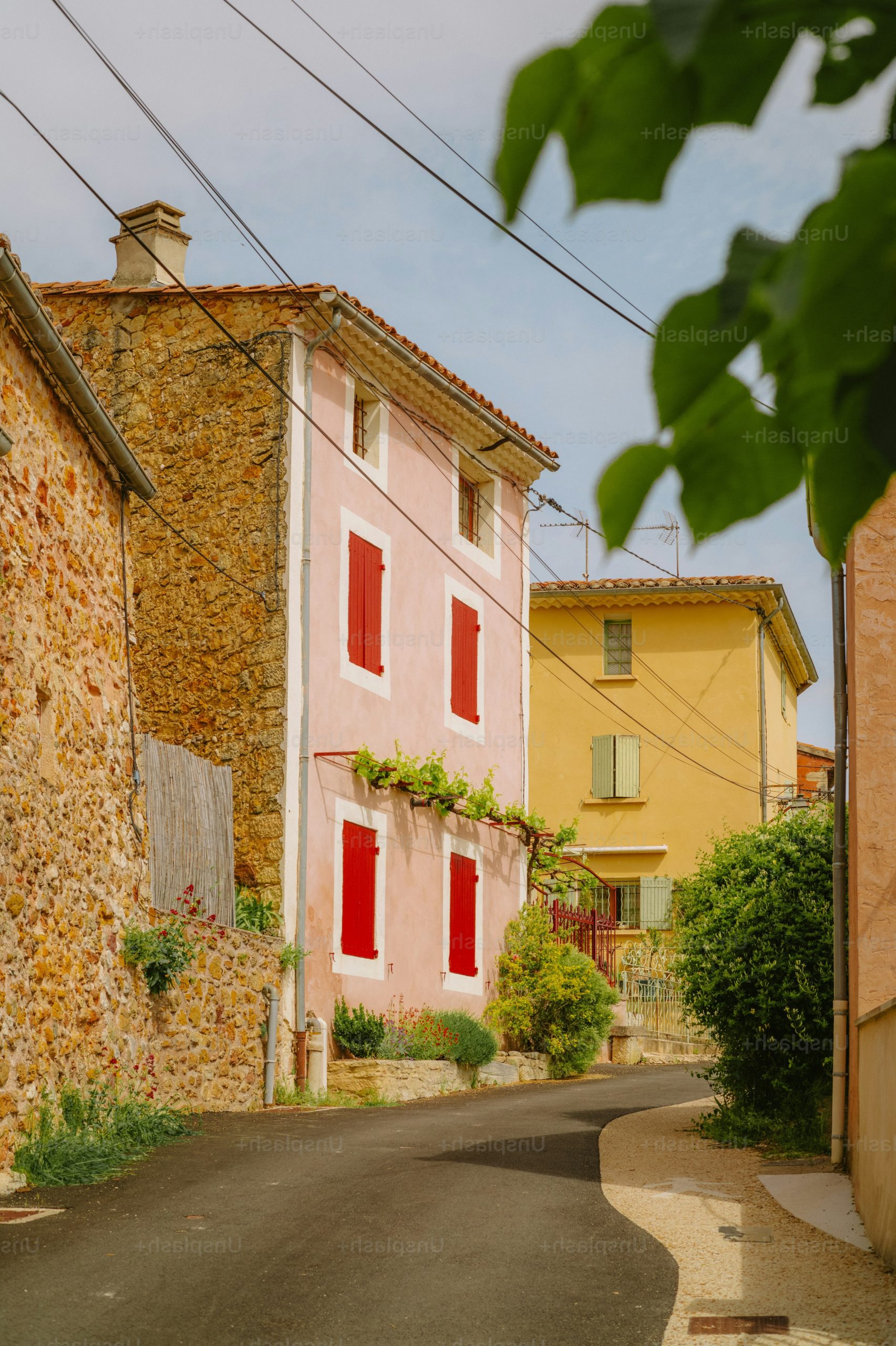 Pink house with red shutters on a village street