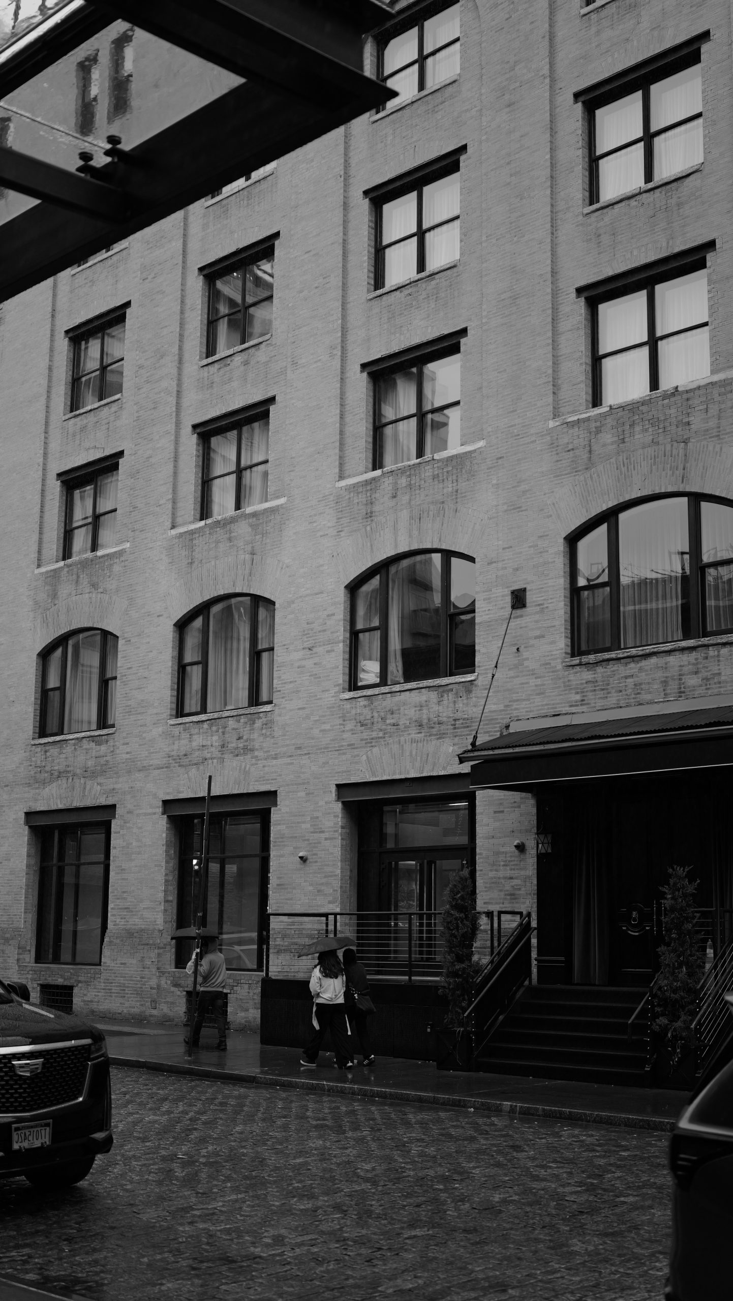 Urban street scene with a building, windows, and pedestrians.