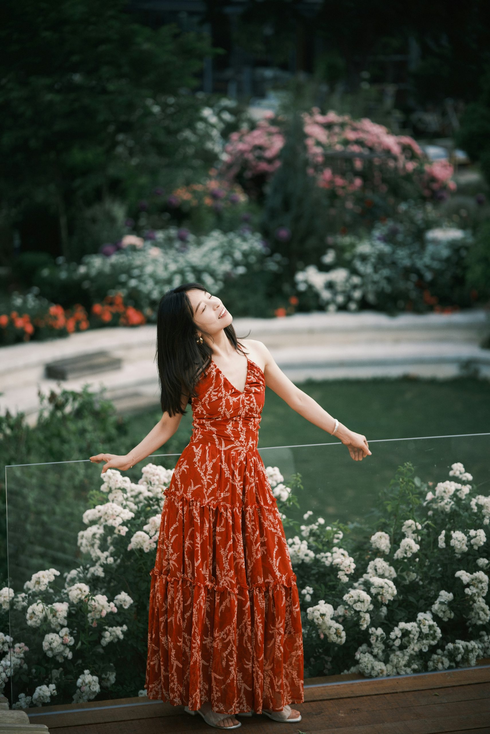 Woman in red dress enjoying a garden