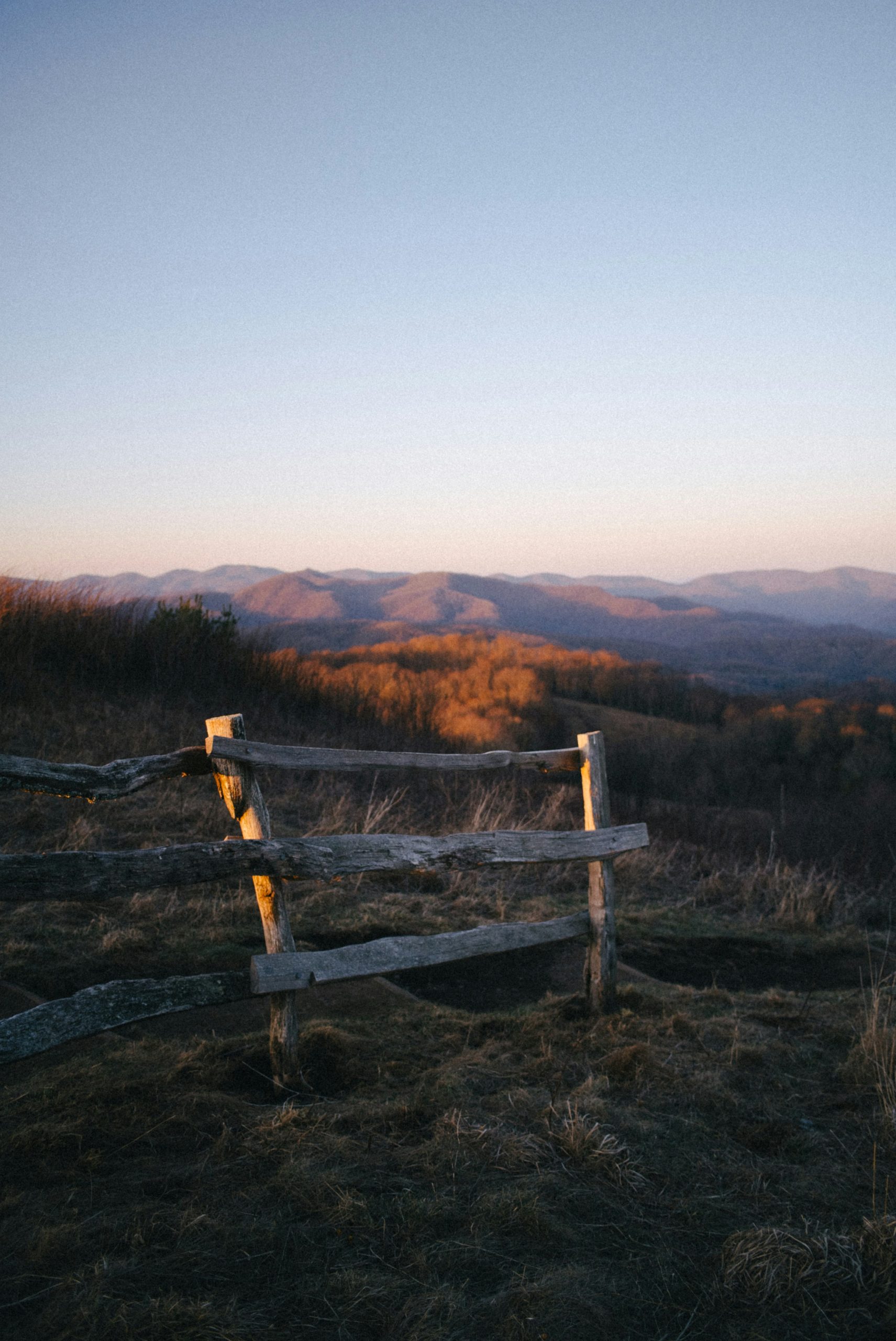 Wooden fence in rolling hills at sunset