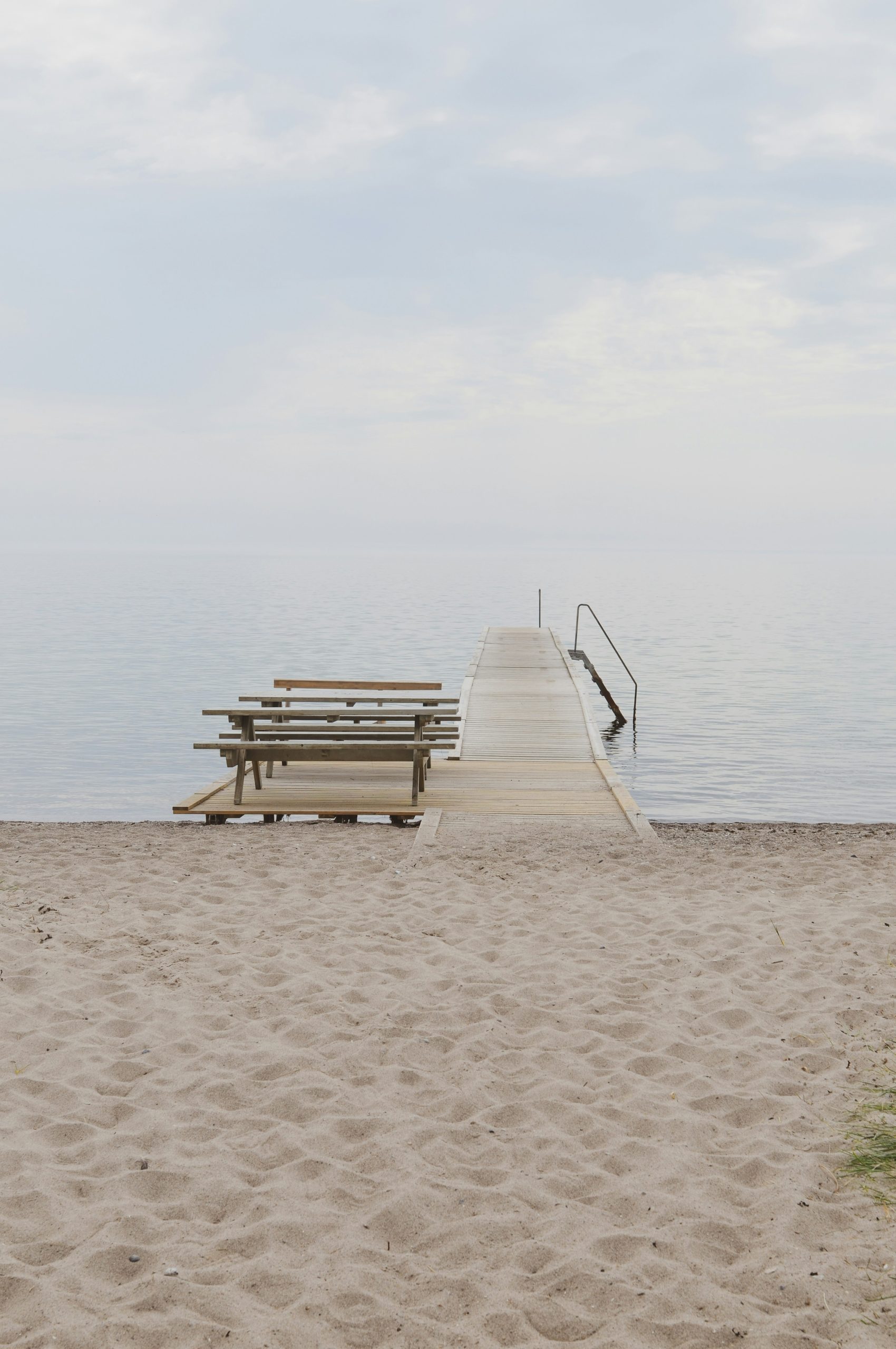 Wooden pier with picnic tables on a sandy beach