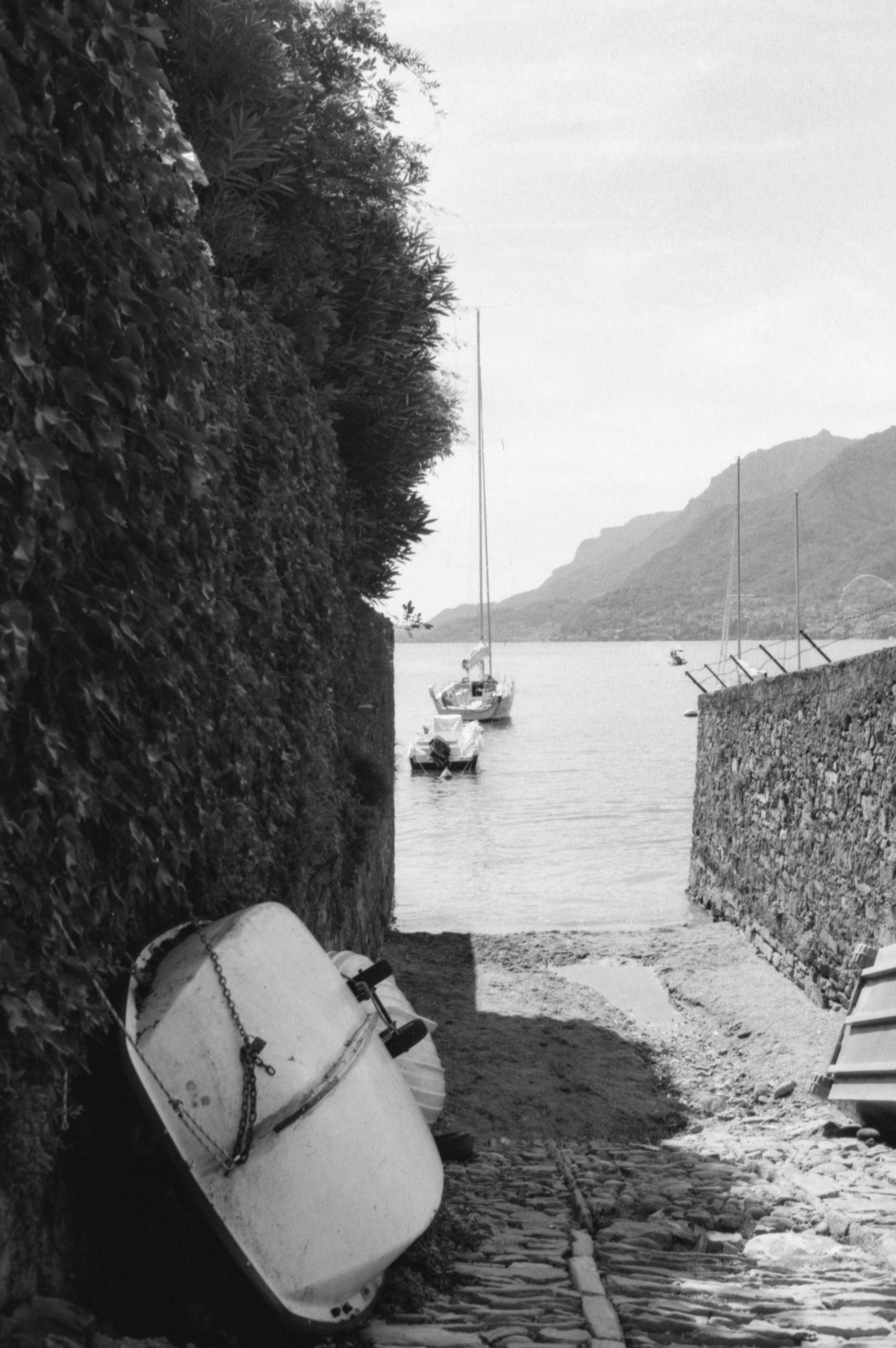 Boats on water seen from a cobbled path.