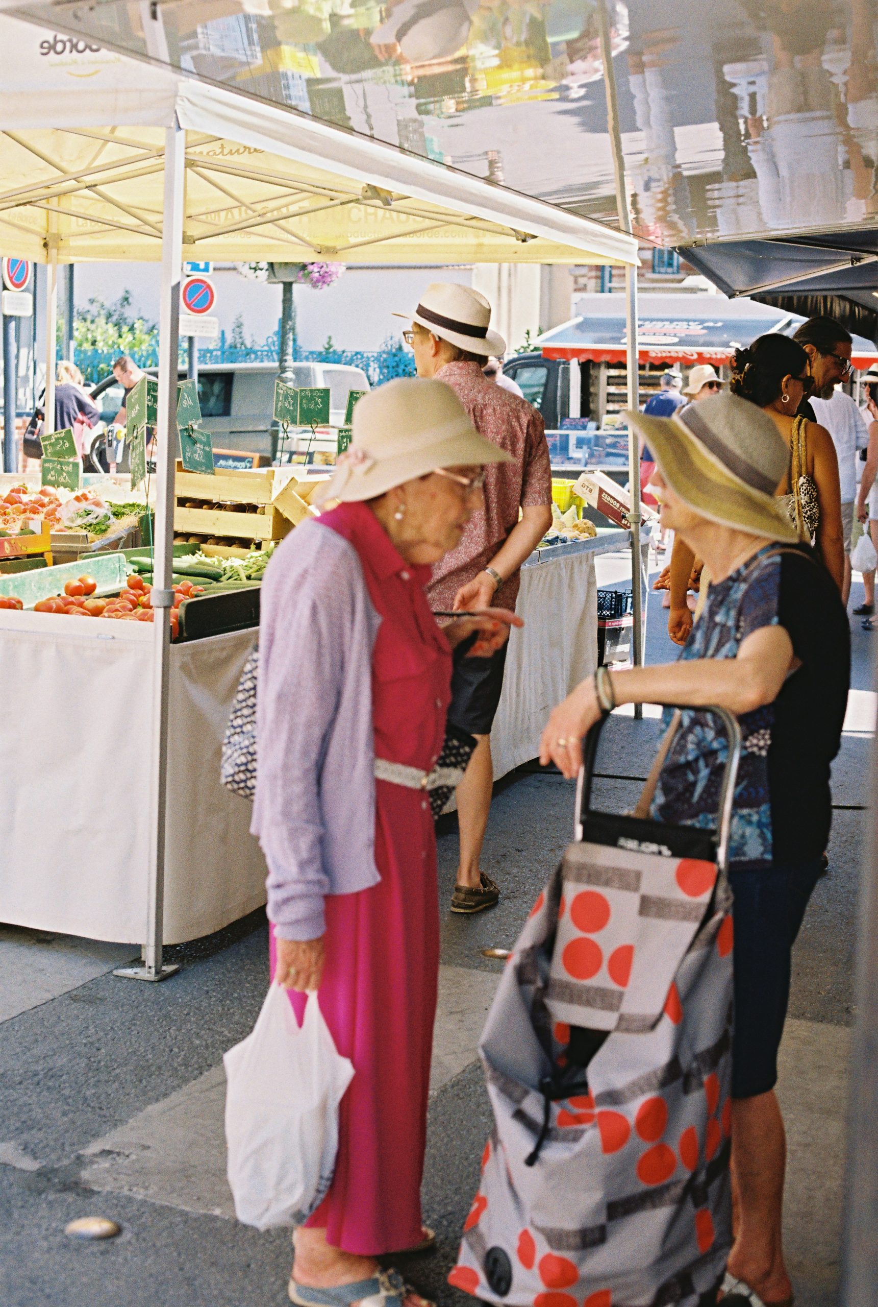 Elderly women chatting at an outdoor produce market