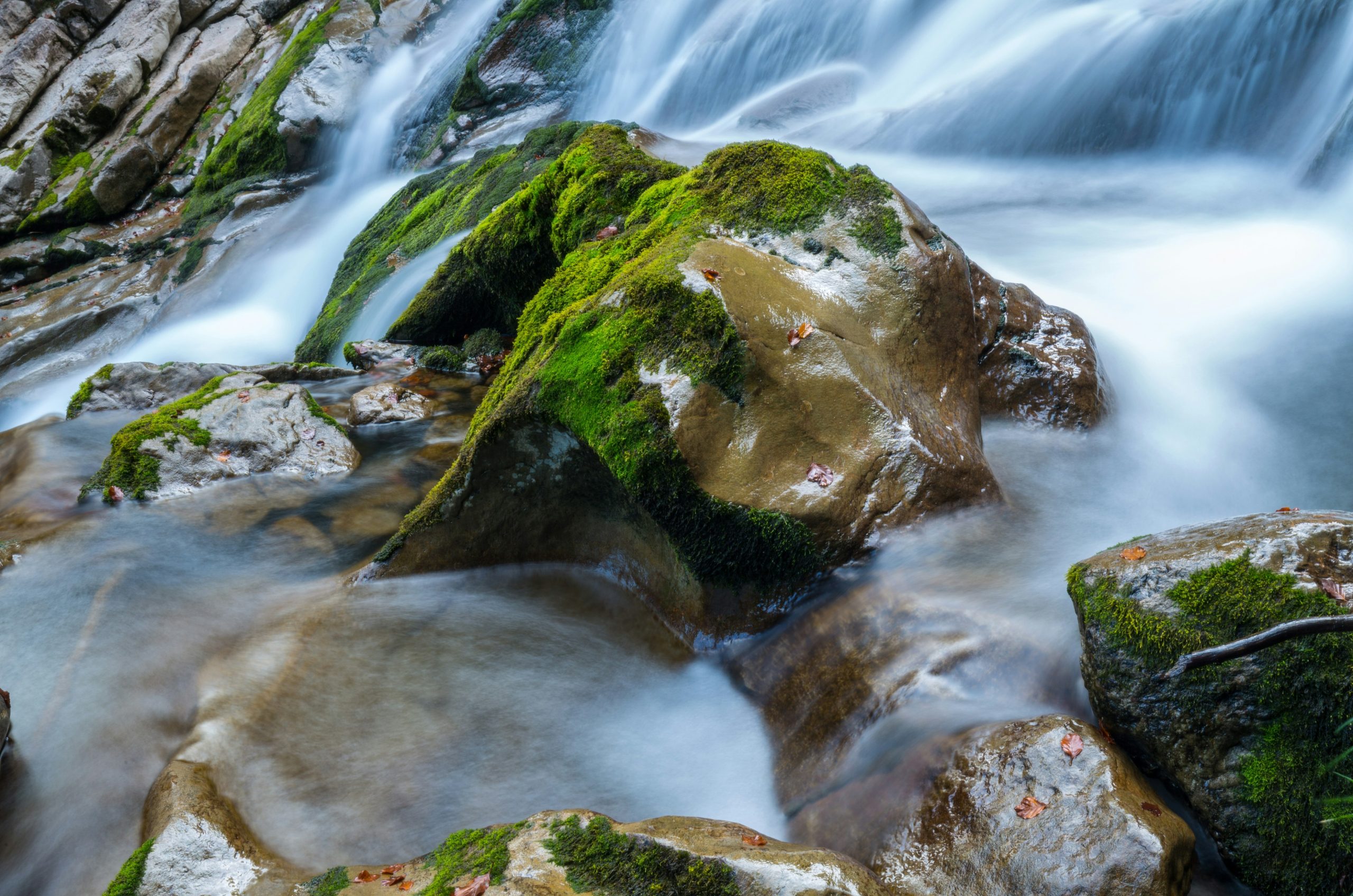 Long exposure waterfall flowing over moss-covered rocks.