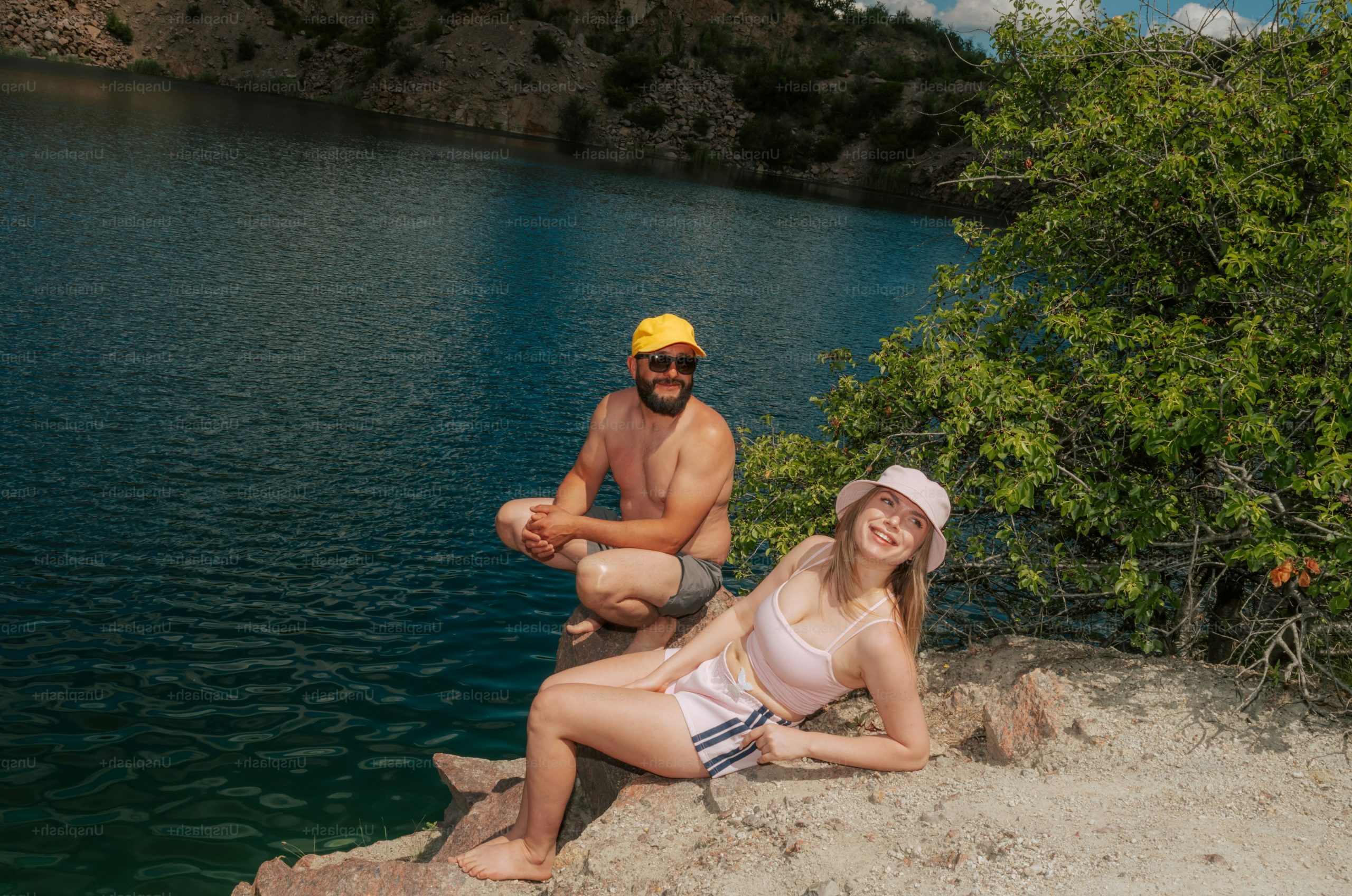 Man and woman relaxing by blue quarry lake