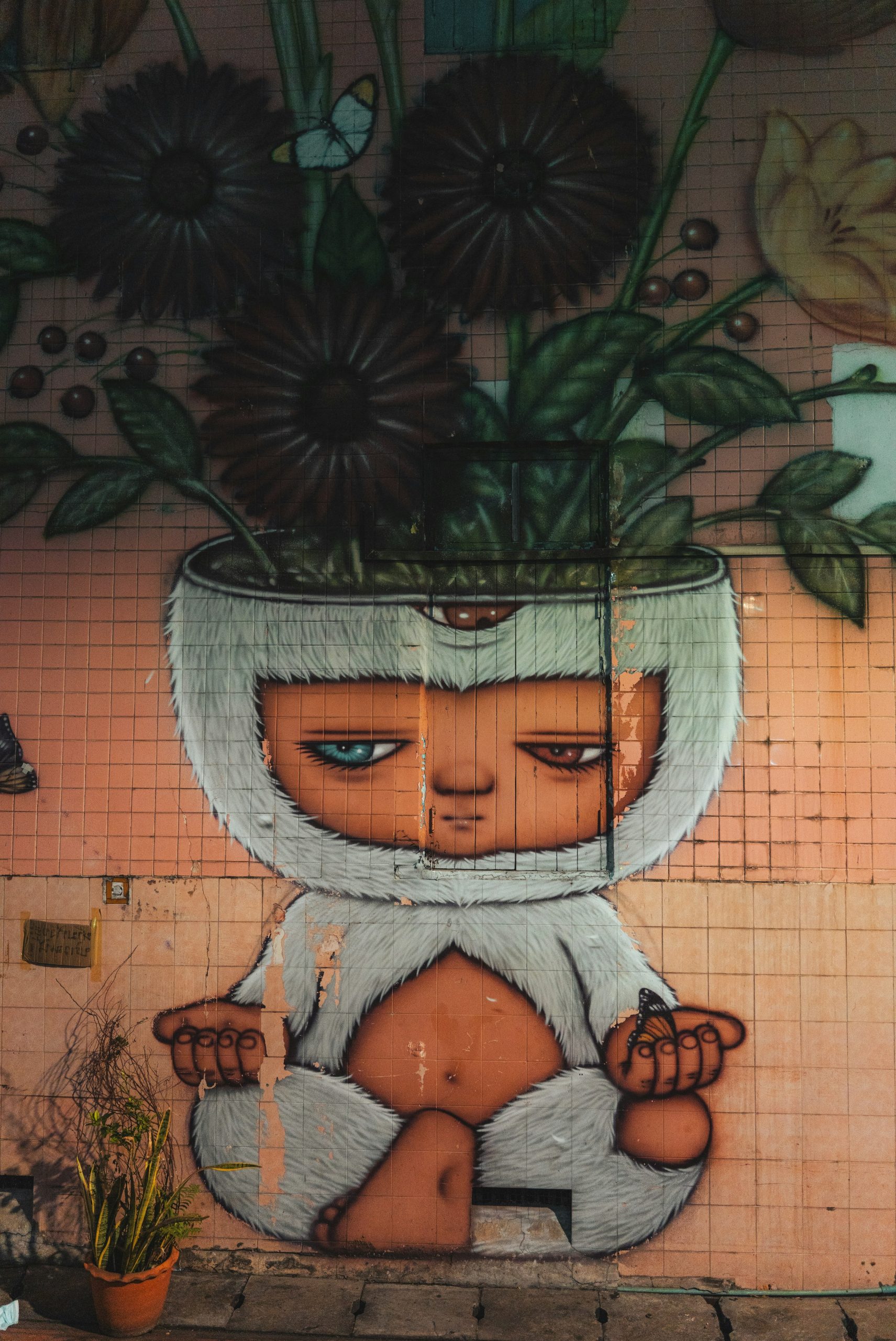 Street art mural of a meditating yeti-like creature with flowers.