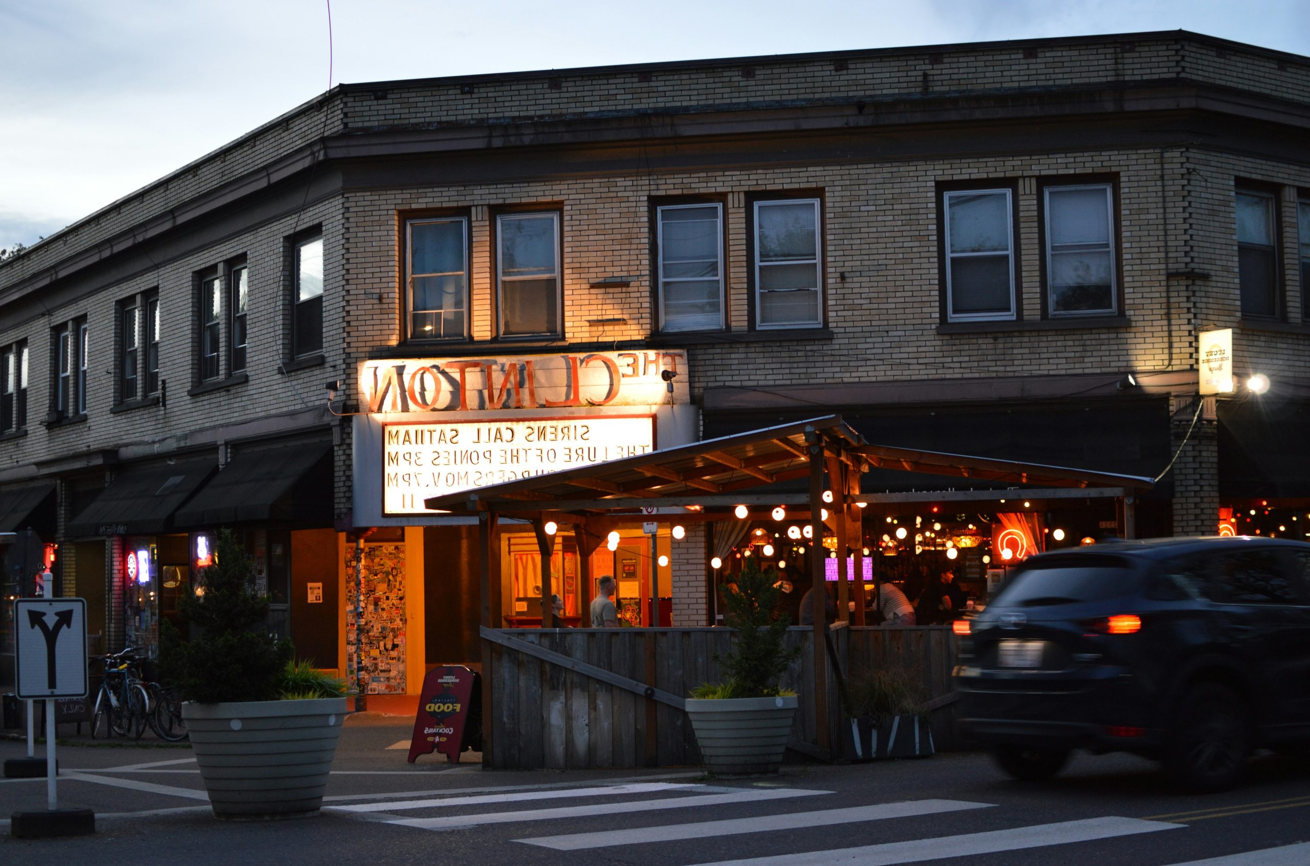 The clinton theater building with an outdoor patio at dusk.