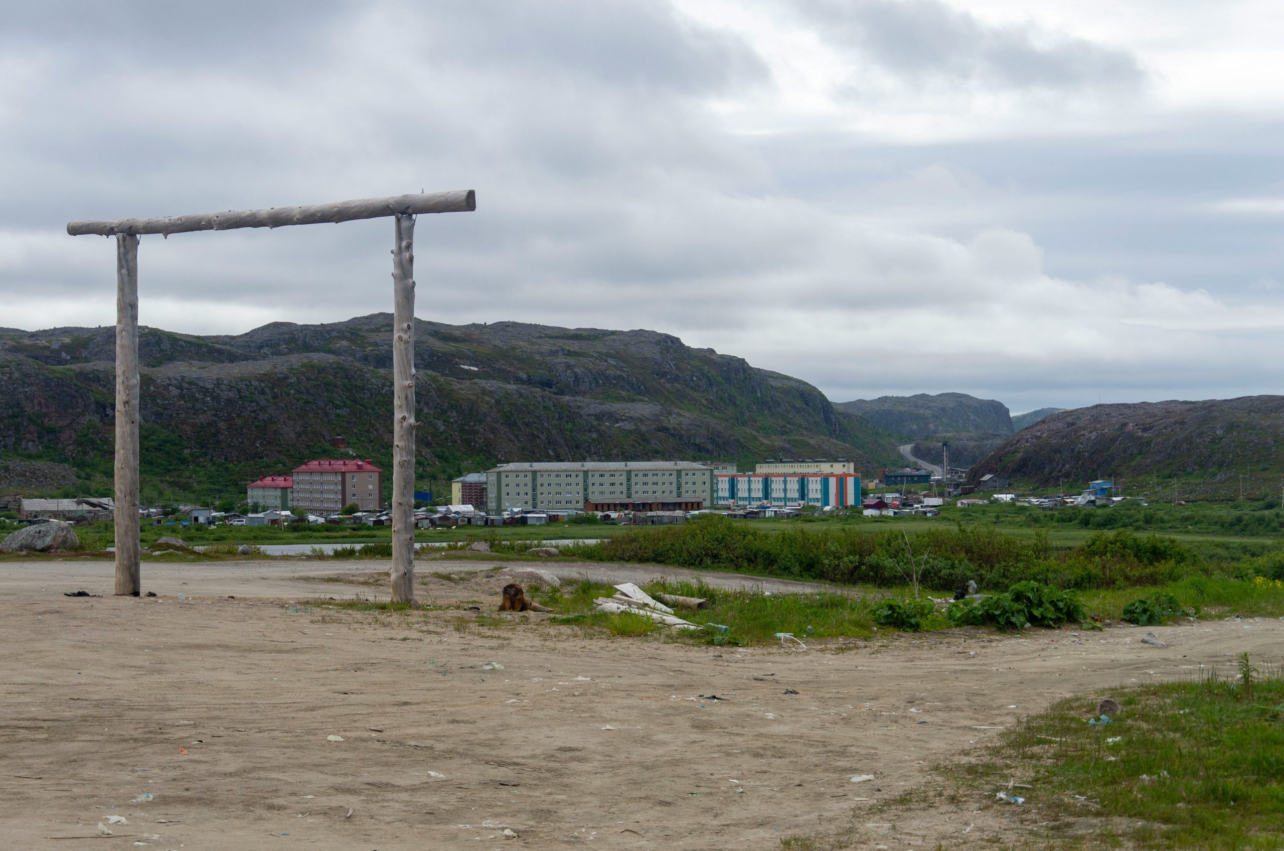 Village in a mountainous landscape with a wooden gateway.