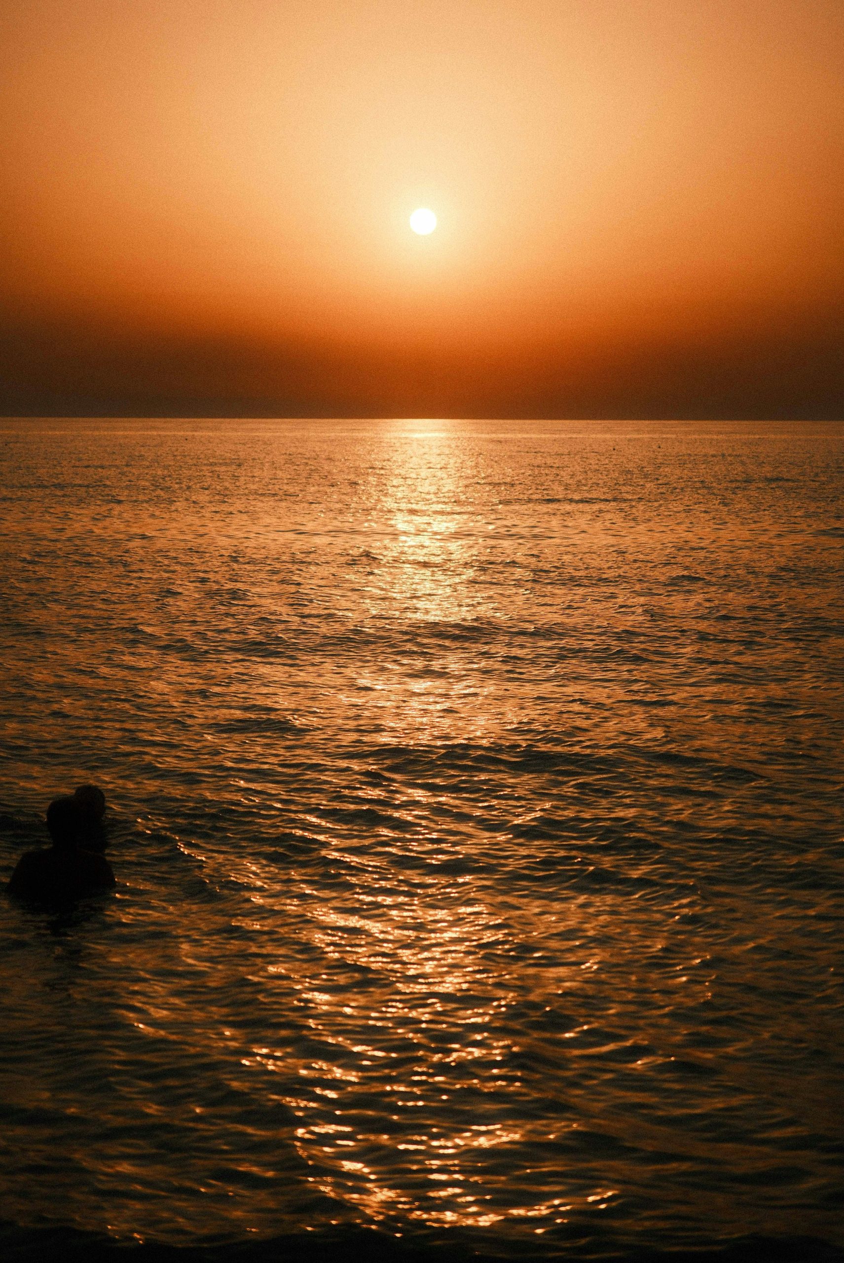 A vibrant orange sunset over a calm ocean.