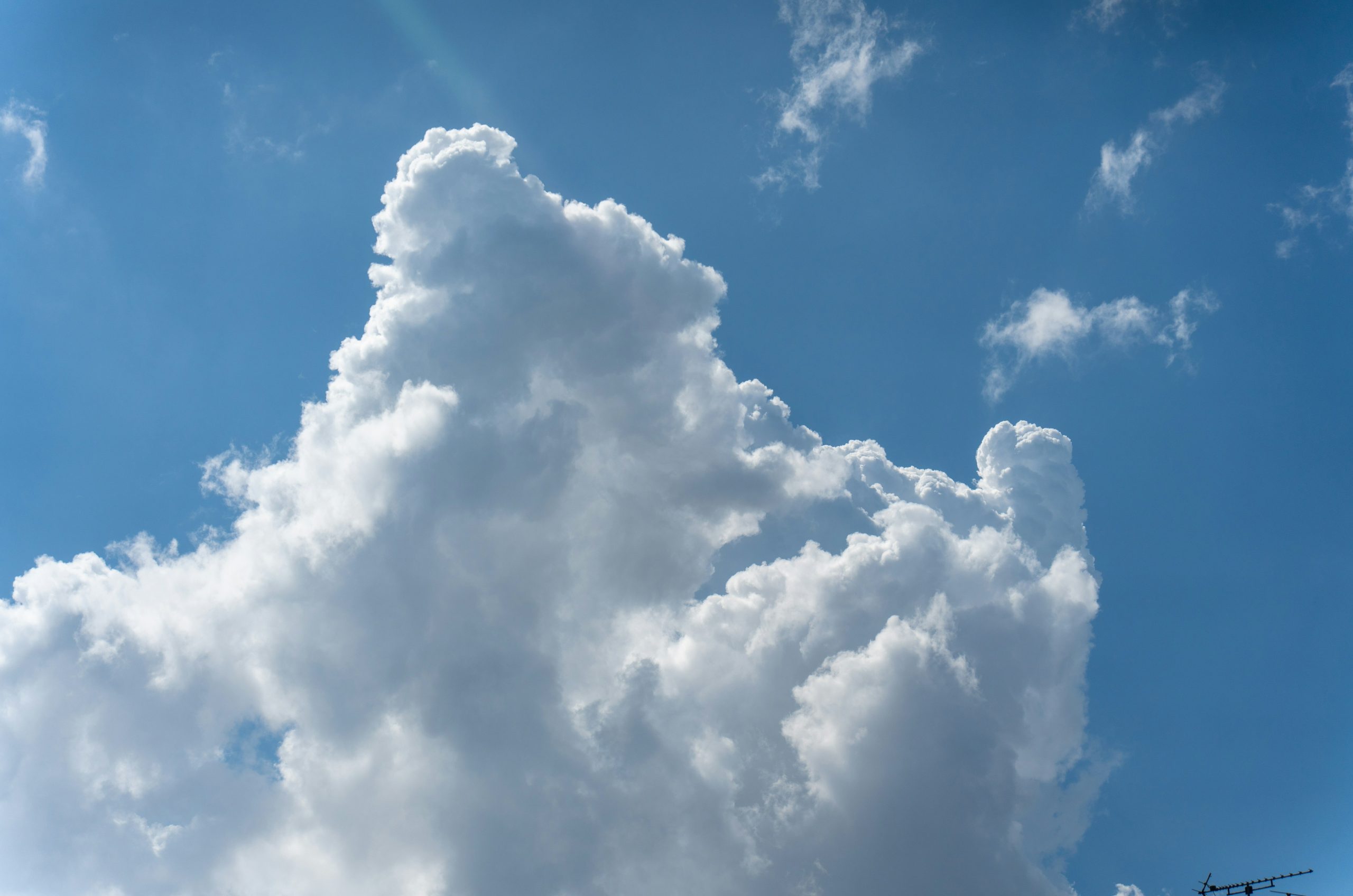 A large white cumulus cloud against a bright blue sky.
