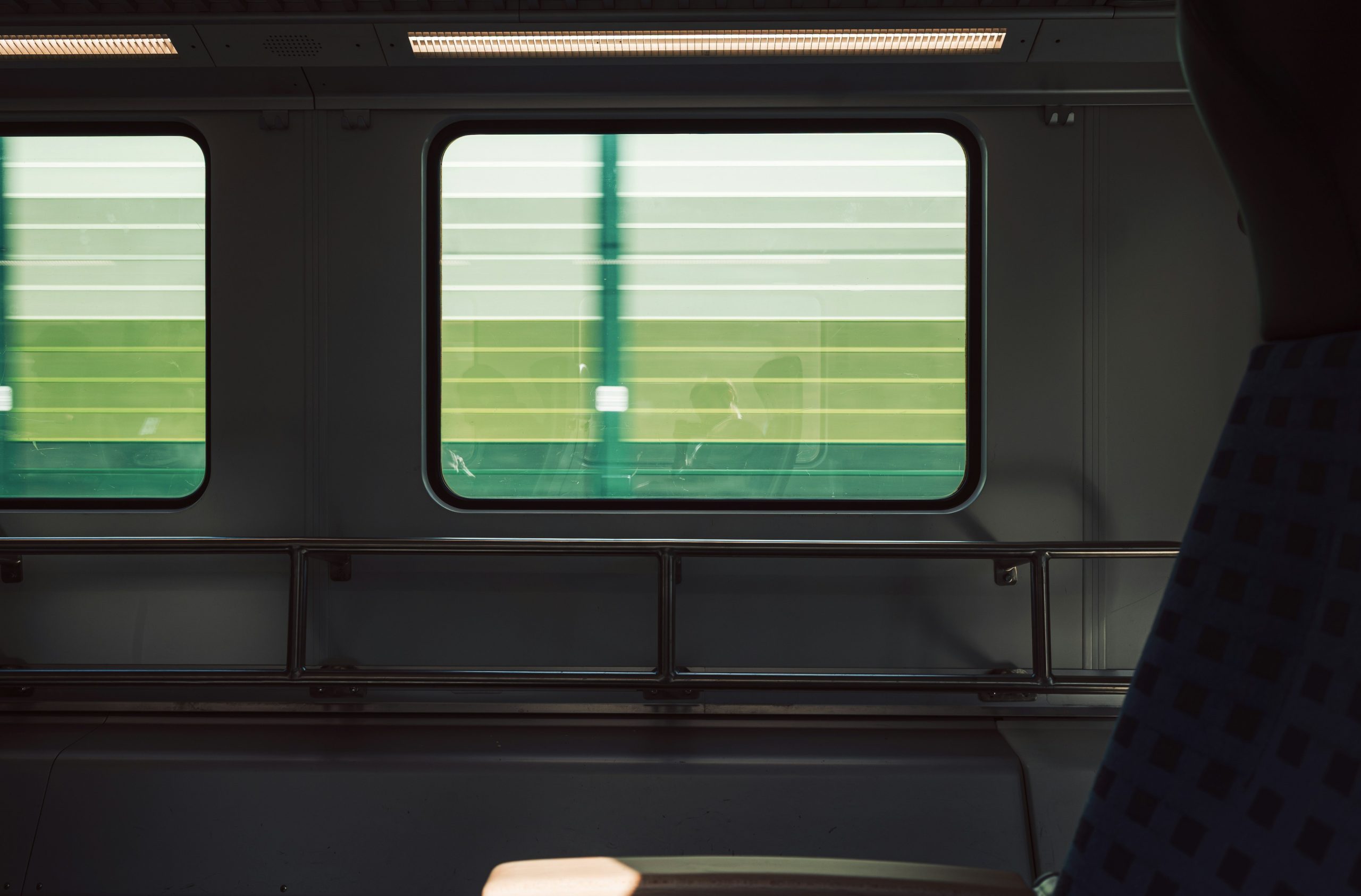 A view through a train window showing motion blur of green scenery in Berlin.