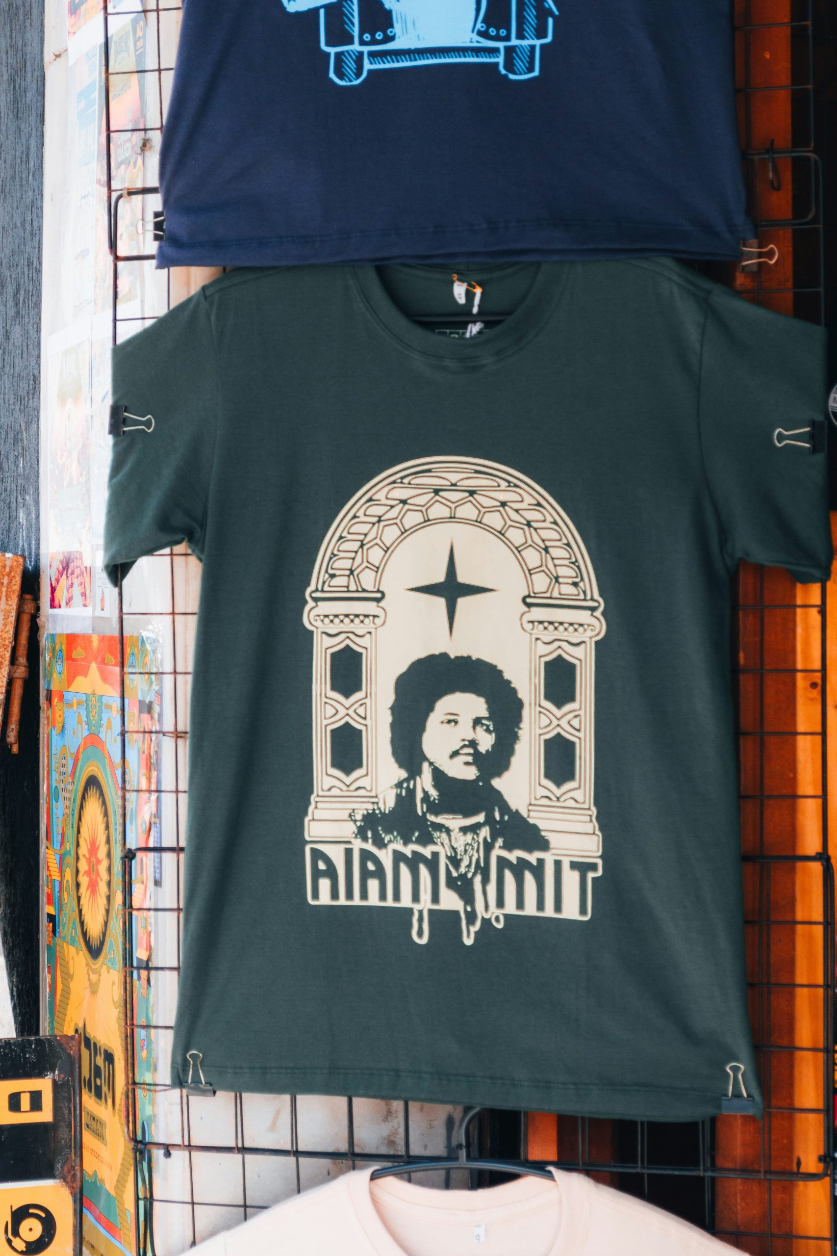 A dark green t-shirt with a graphic of Tim Maia in an archway.