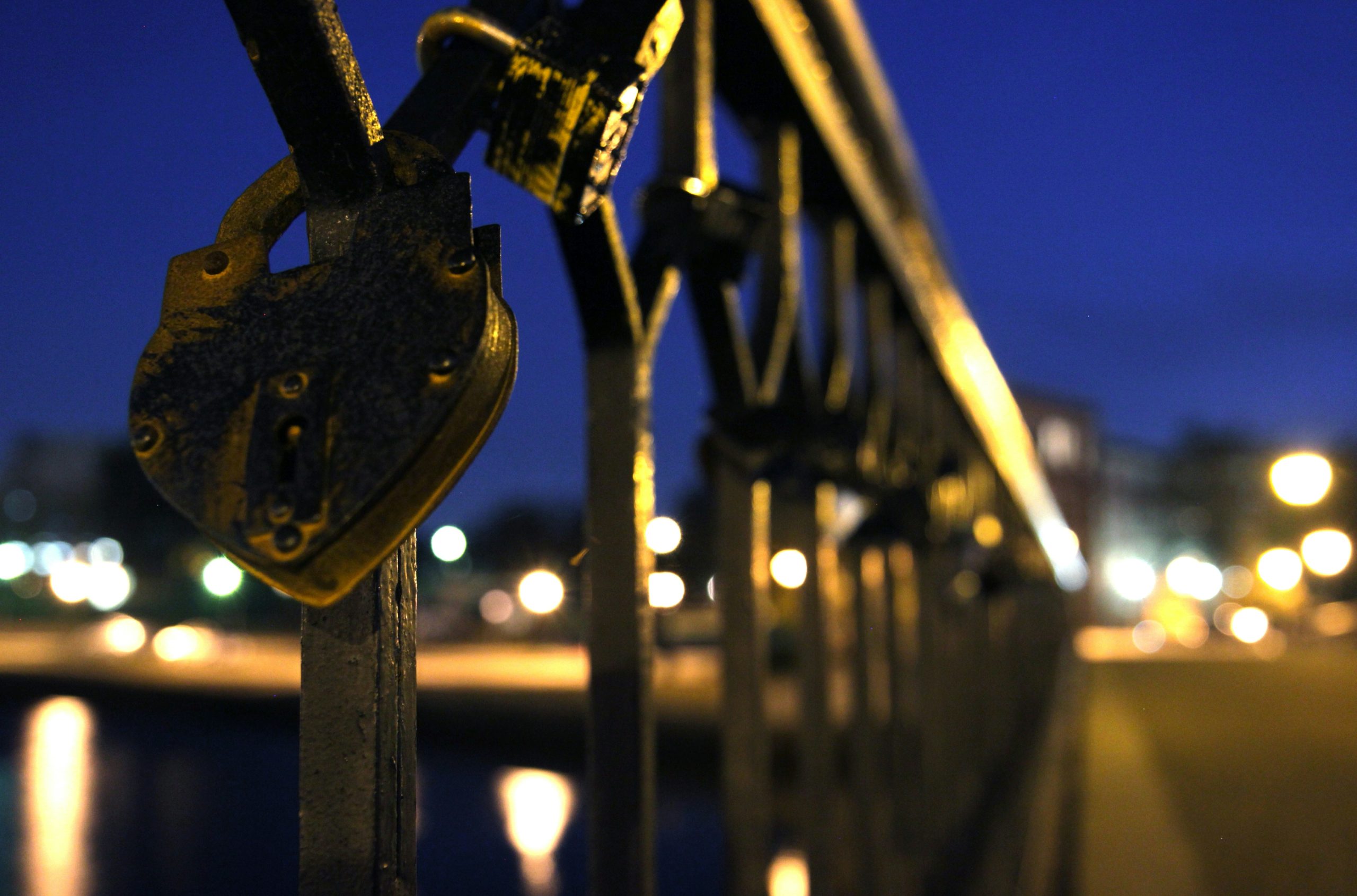 blue padlock on black metal fence during night time