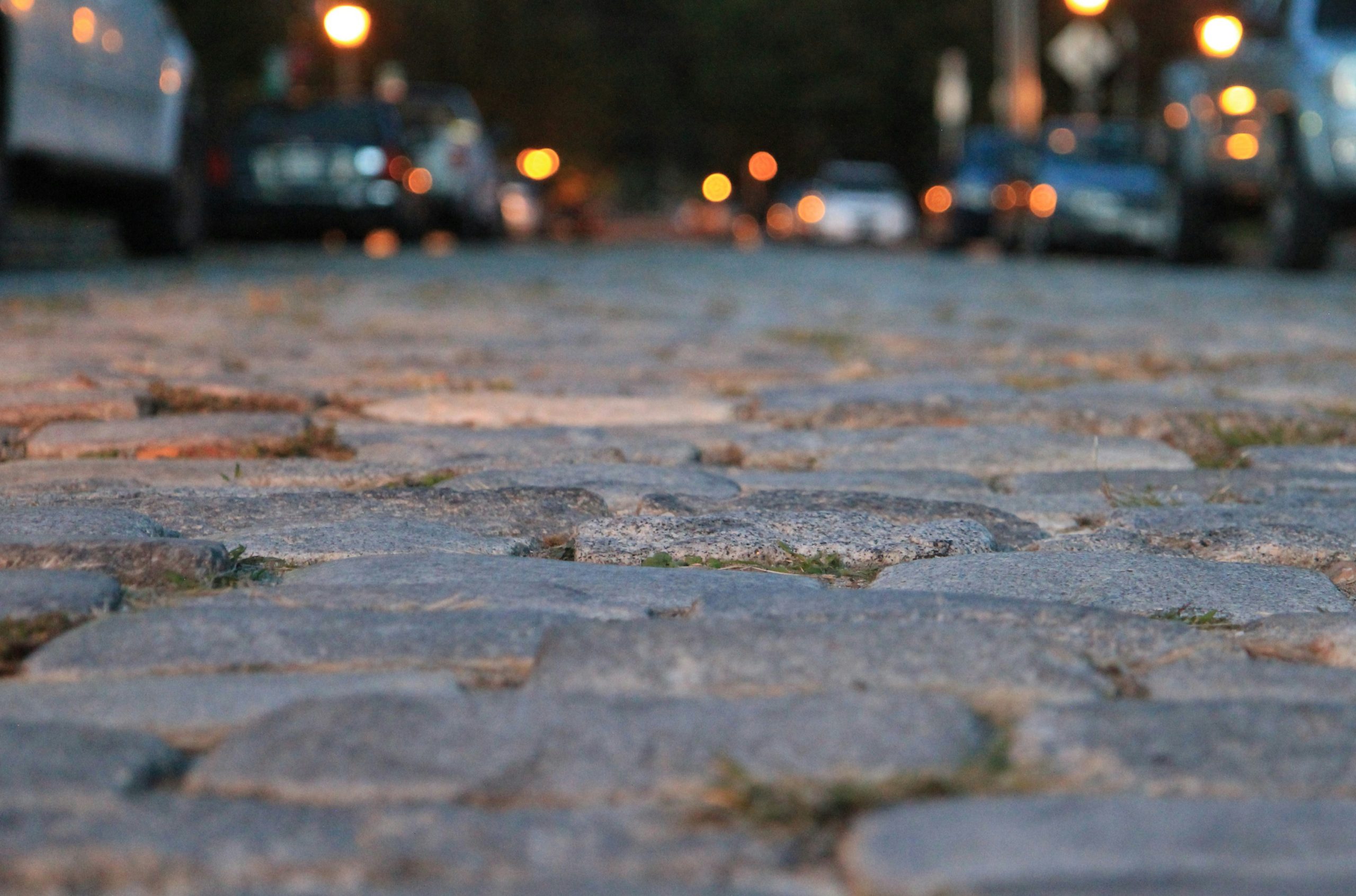 water droplets on gray concrete pavement during night time