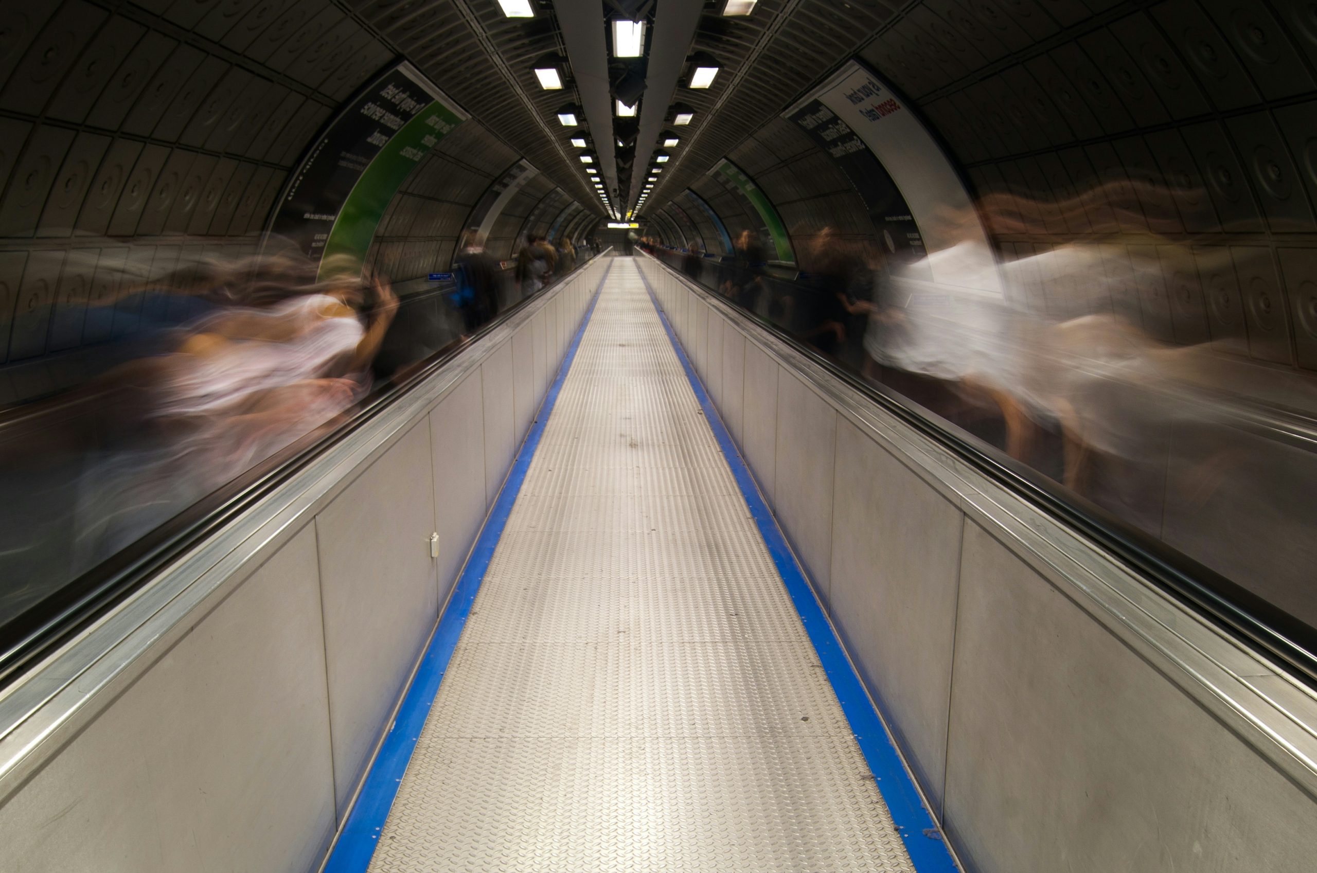 a blurry photo of people riding on an escalator