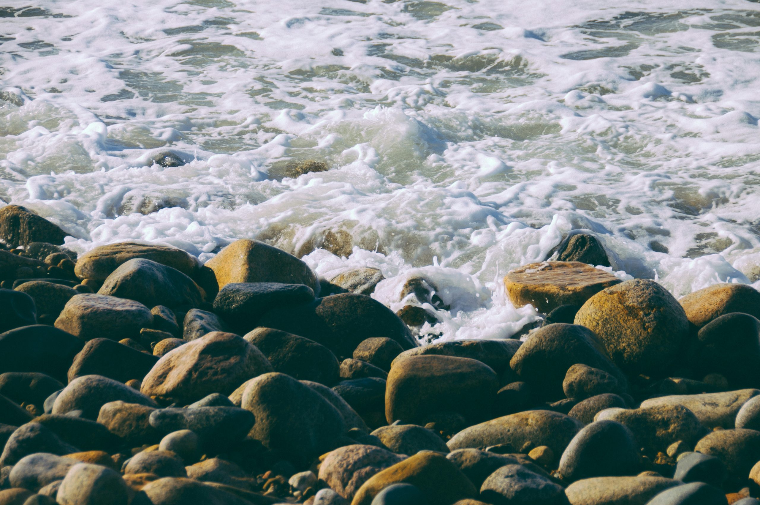 brown and black rocks on body of water