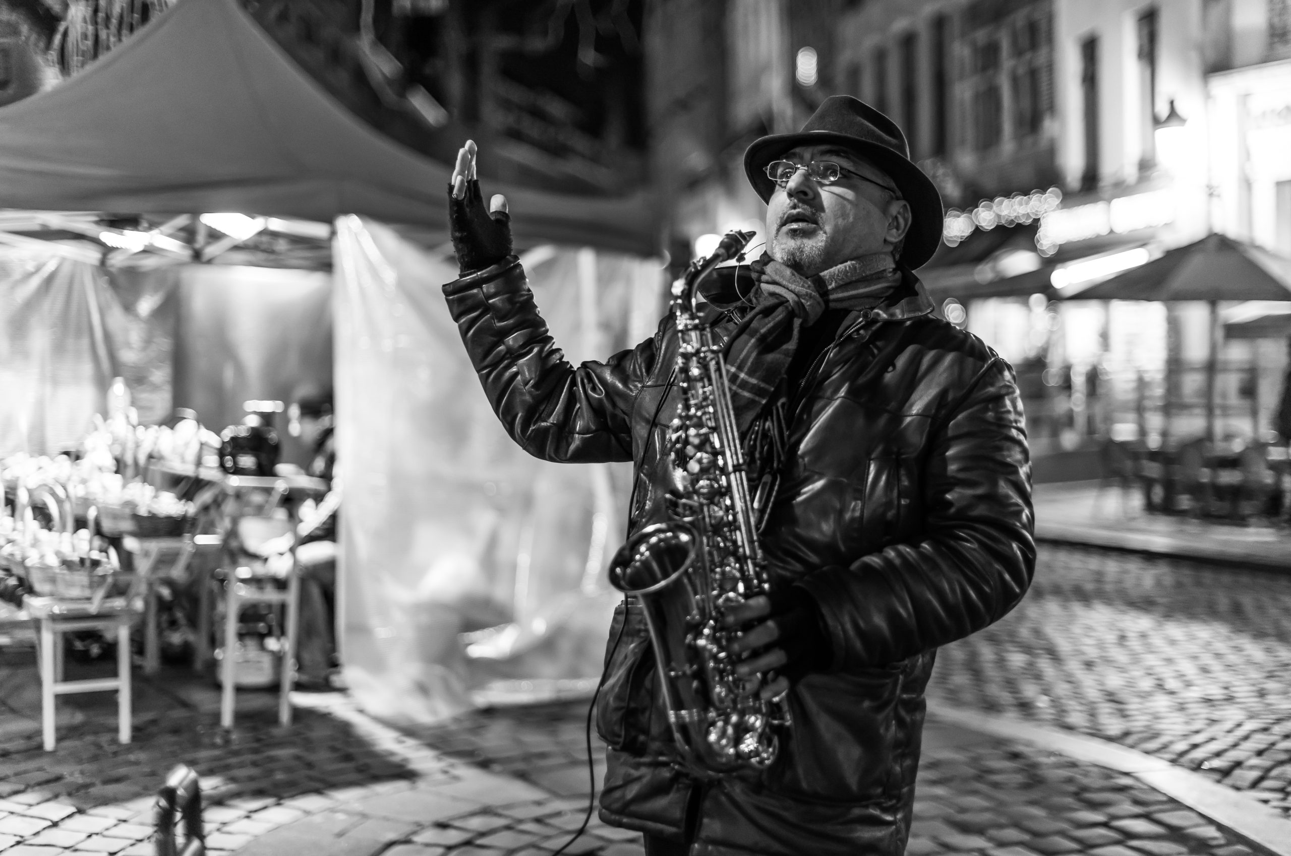 grayscale photo of man playing saxophone
