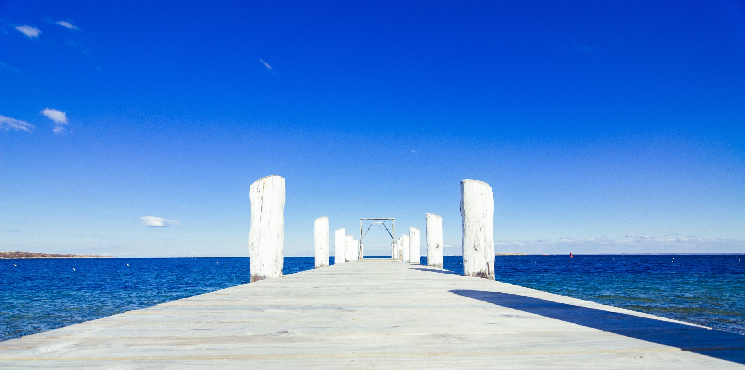 brown wooden dock on blue sea under blue sky during daytime