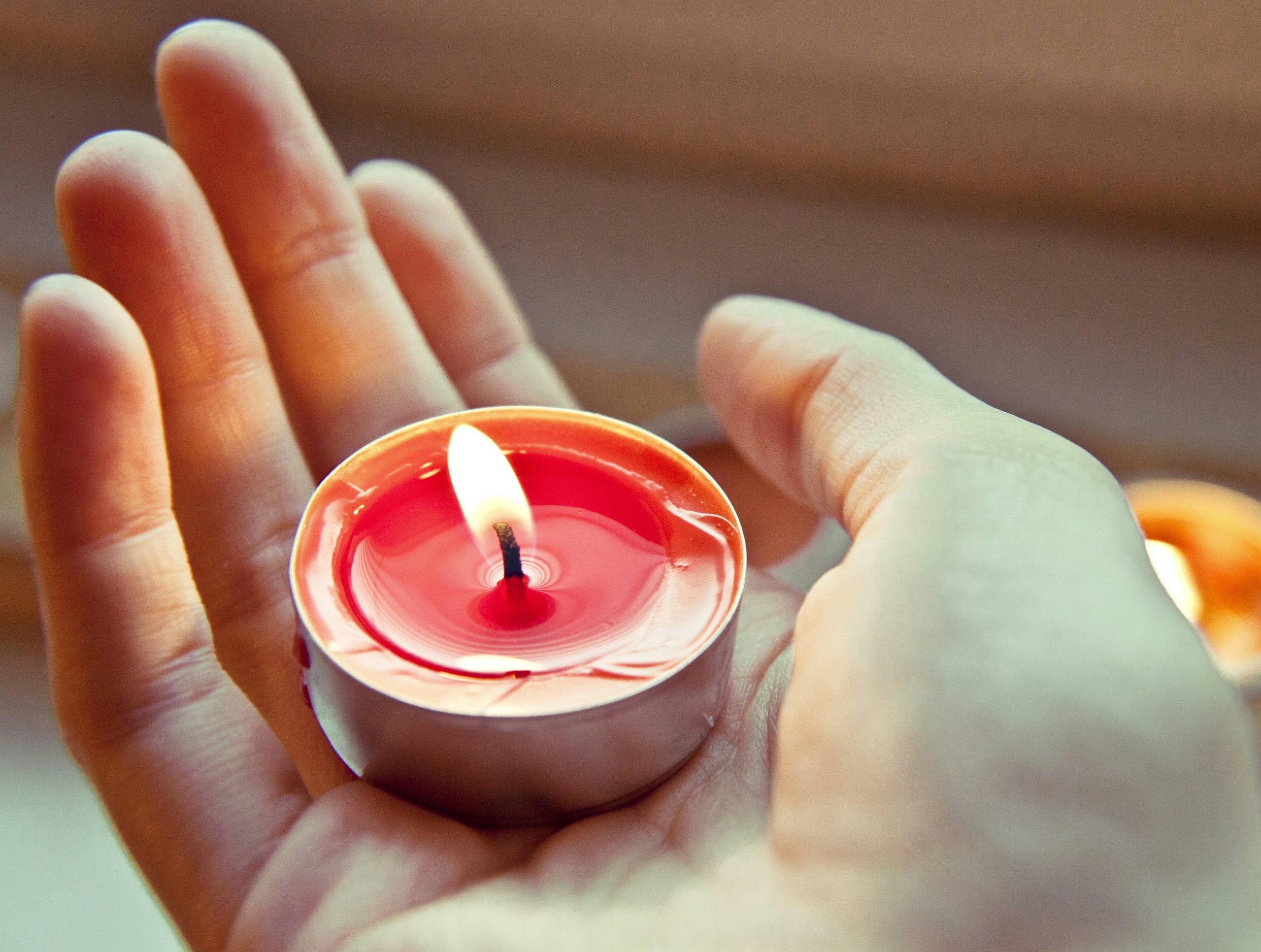 person holding red and white candle