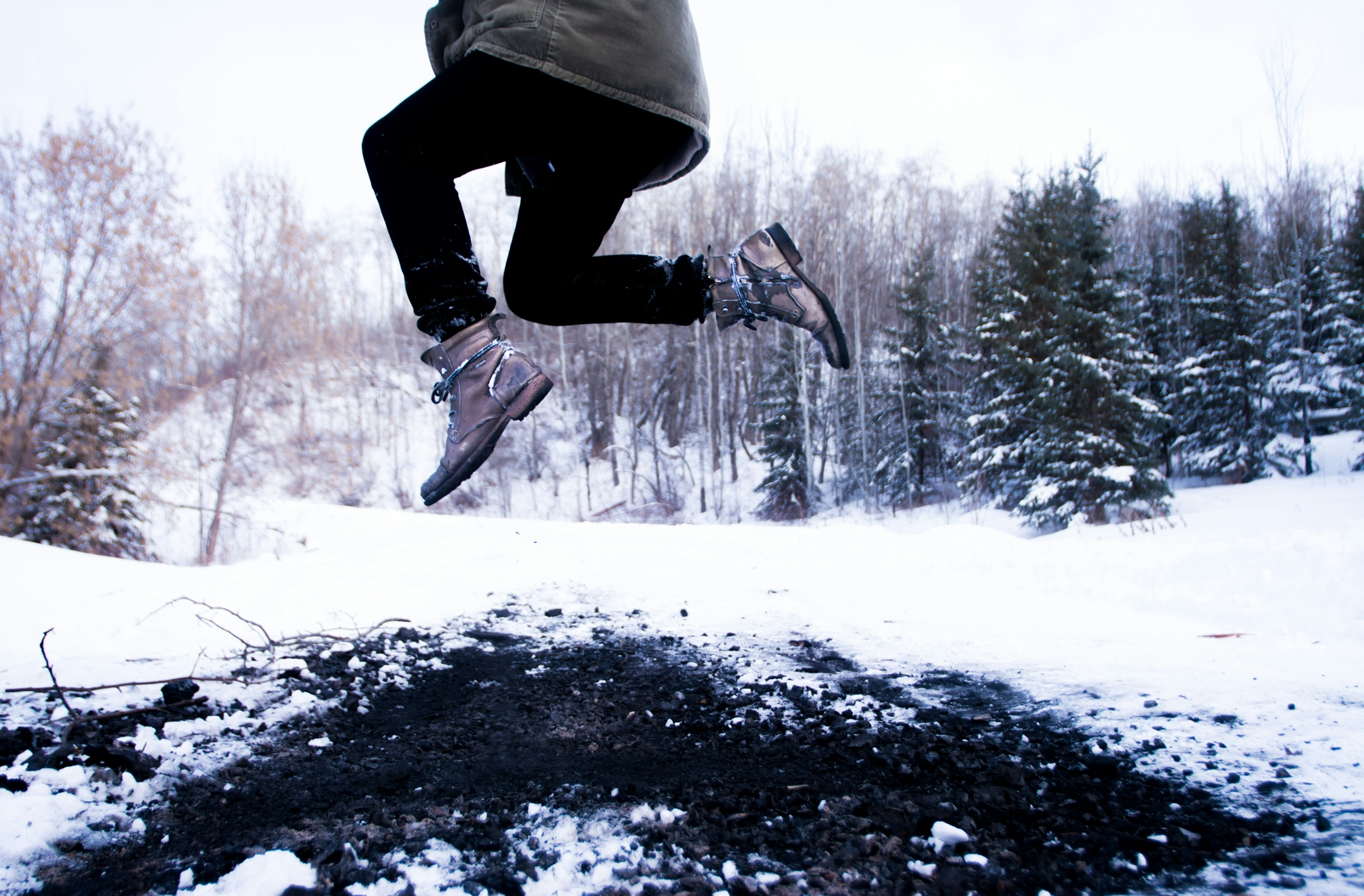 person jumping over black soil