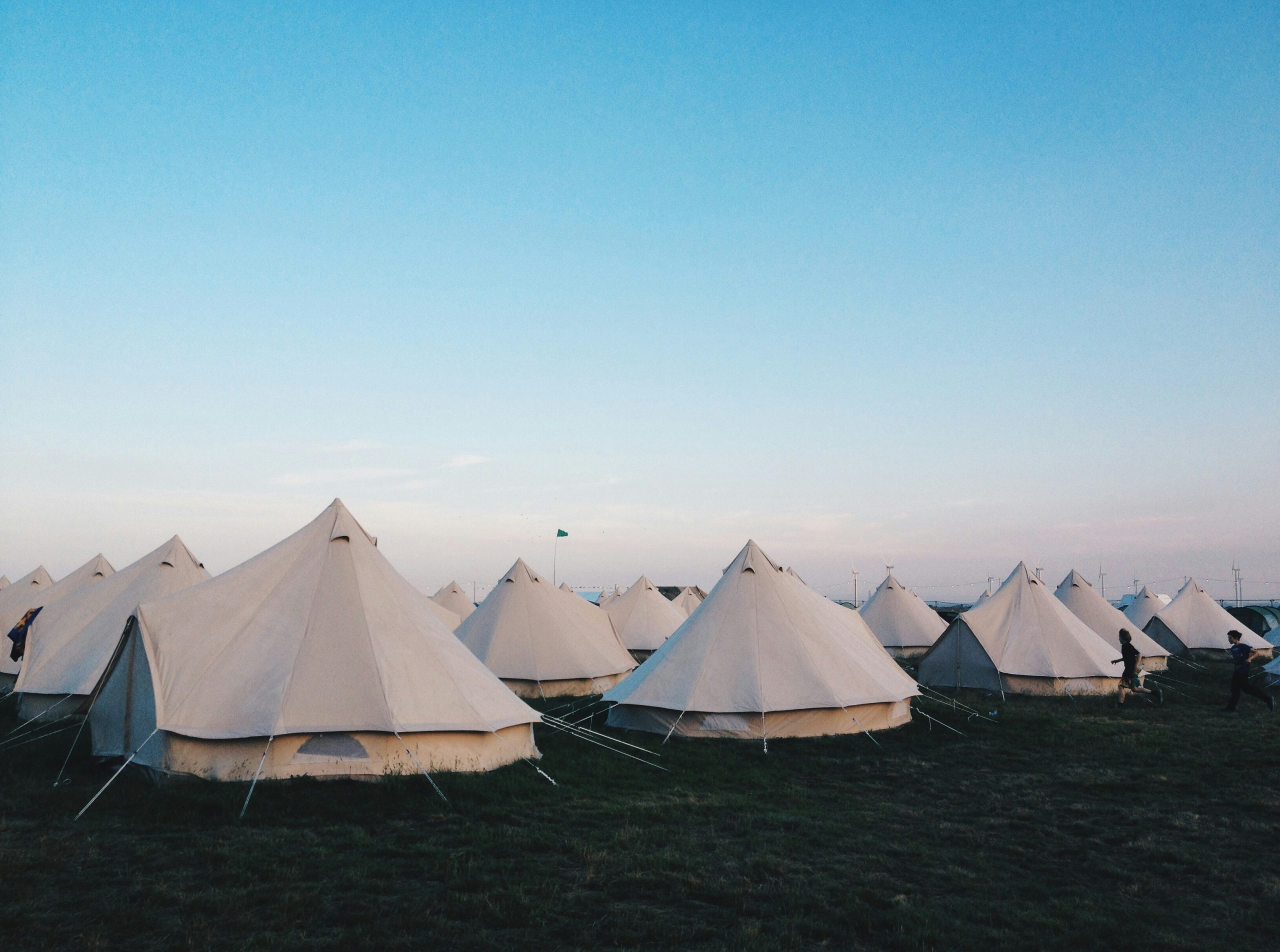 white tents on grass field under clear blue sky